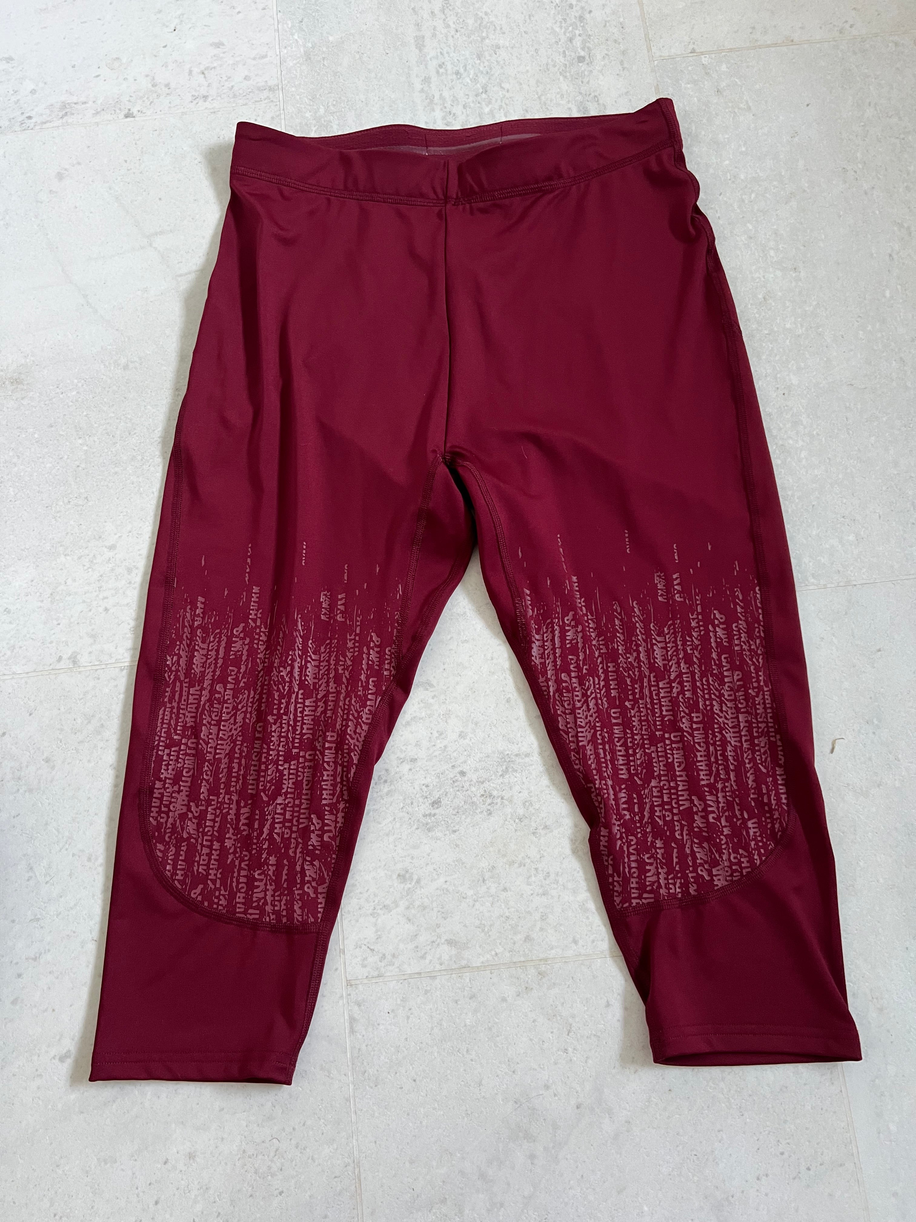 Front view of burgundy Gymshark cropped leggings with patterned detailing on lower legs