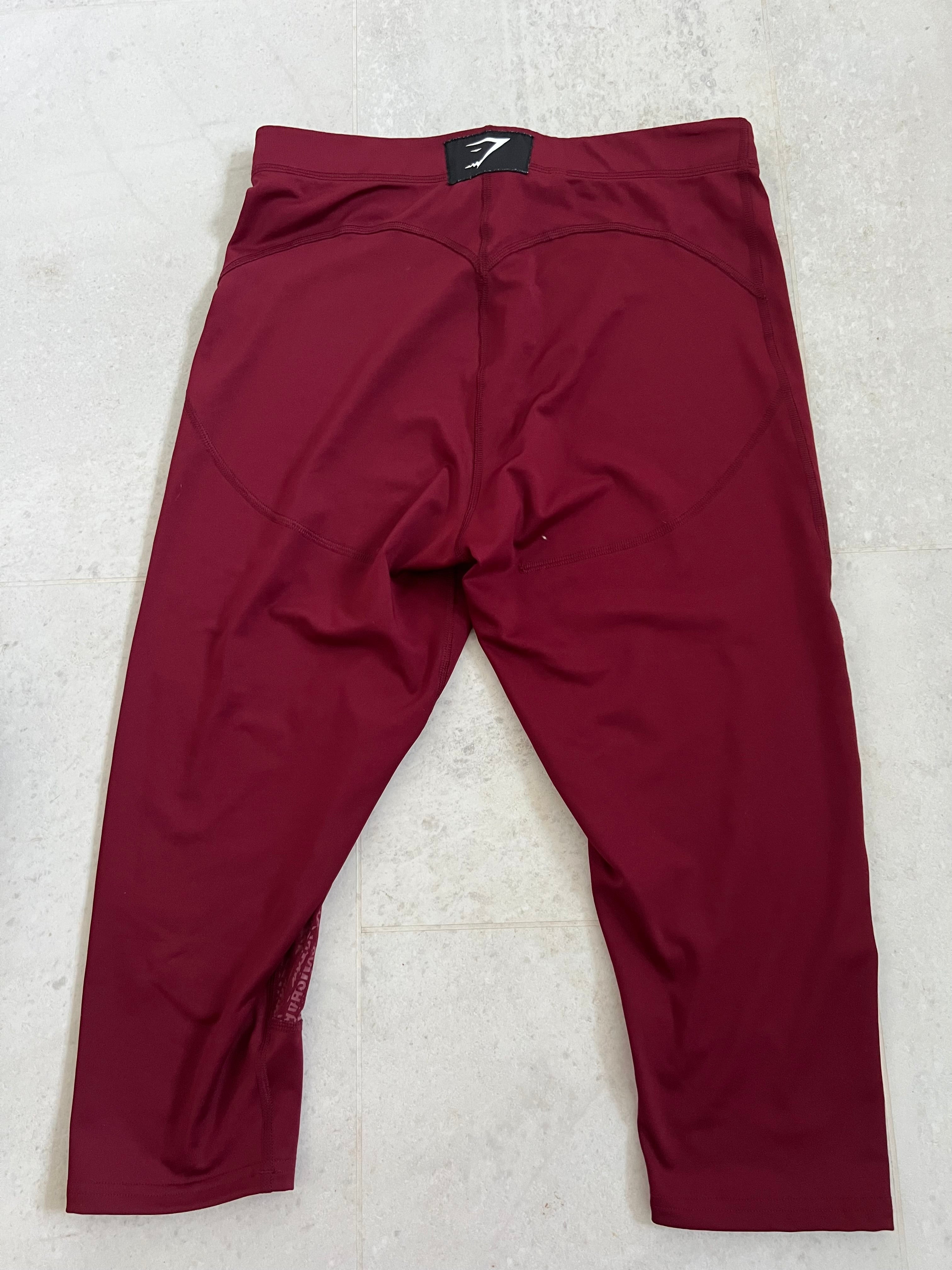 Back view of burgundy Gymshark cropped leggings showing logo patch on waistband