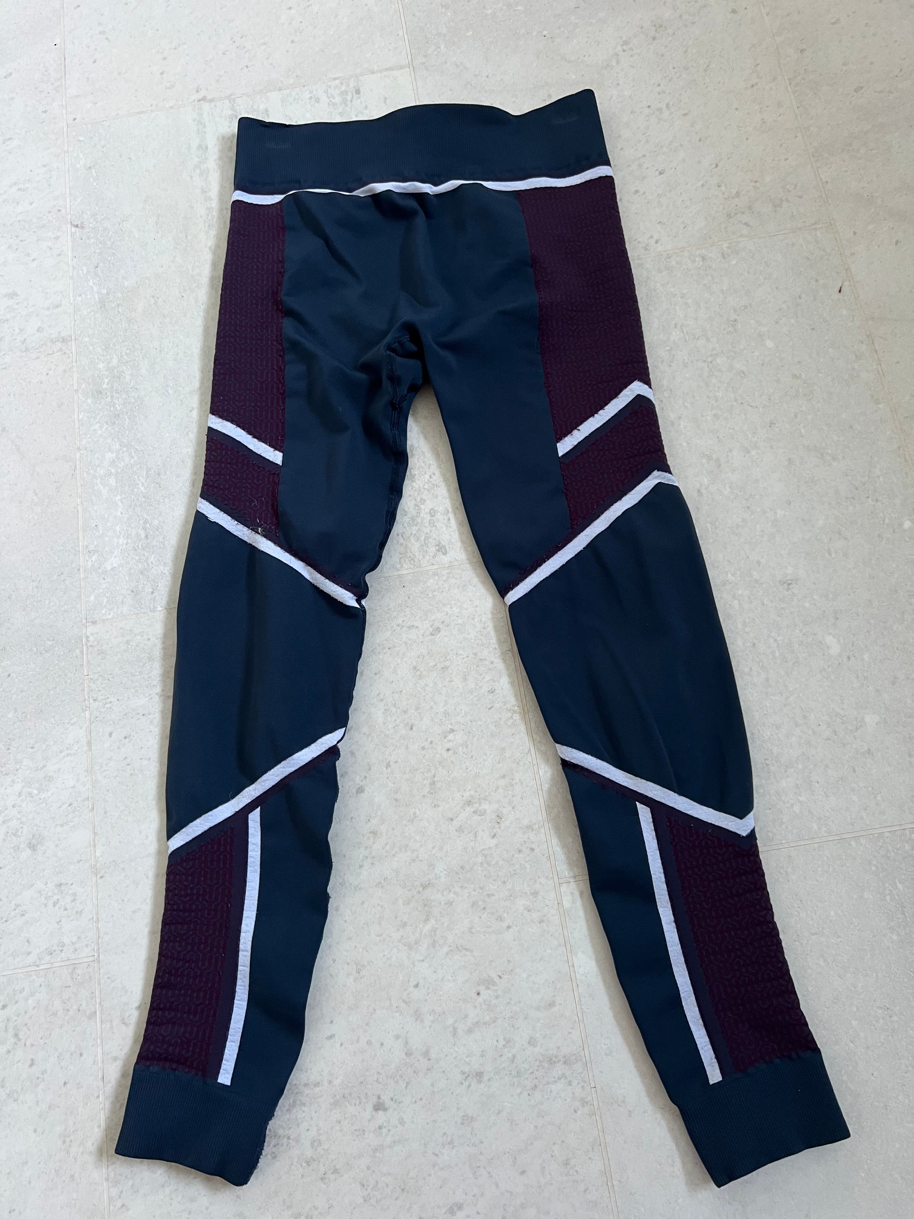 Front view of Sweaty Betty multi-coloured patterned leggings in navy, plum and white