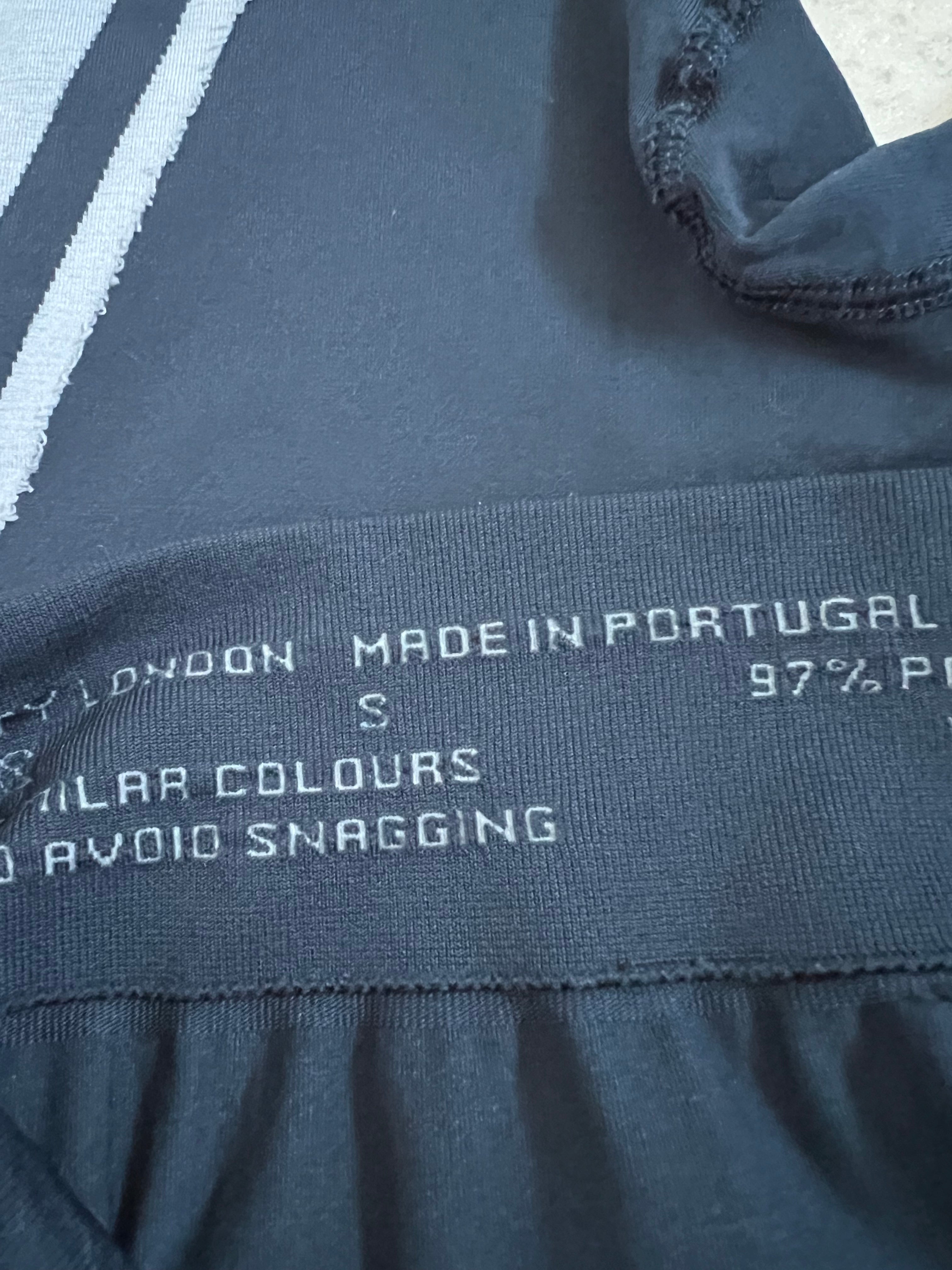 Close-up of inside waistband label showing Sweaty Betty branding, size S, and fabric details made in Portugal