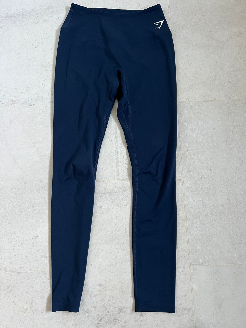 Front view of Gymshark full length blue leggings laid flat