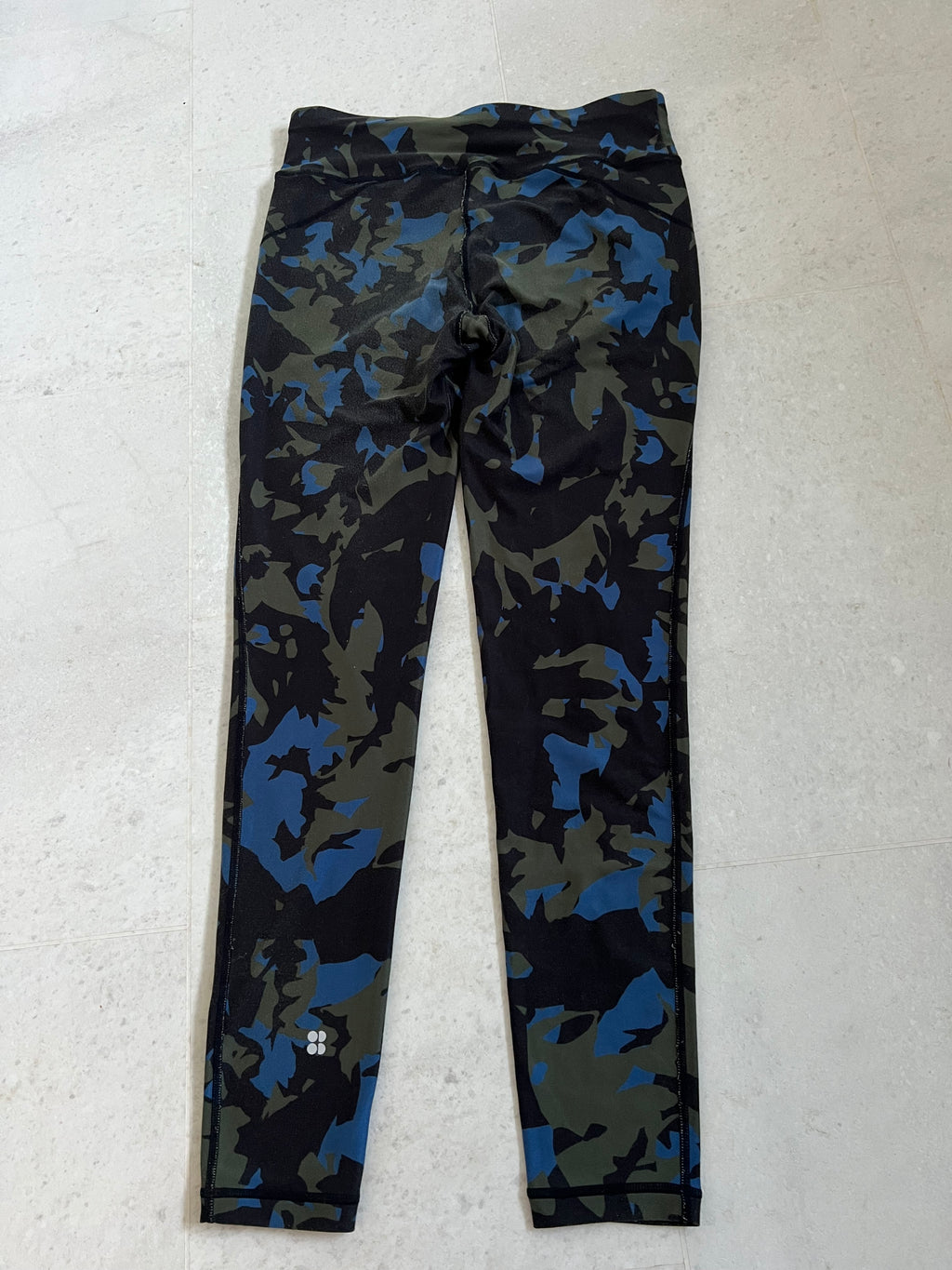 Back view of Sweaty Betty camouflage leggings showing full length and high-rise waistband with logo detail