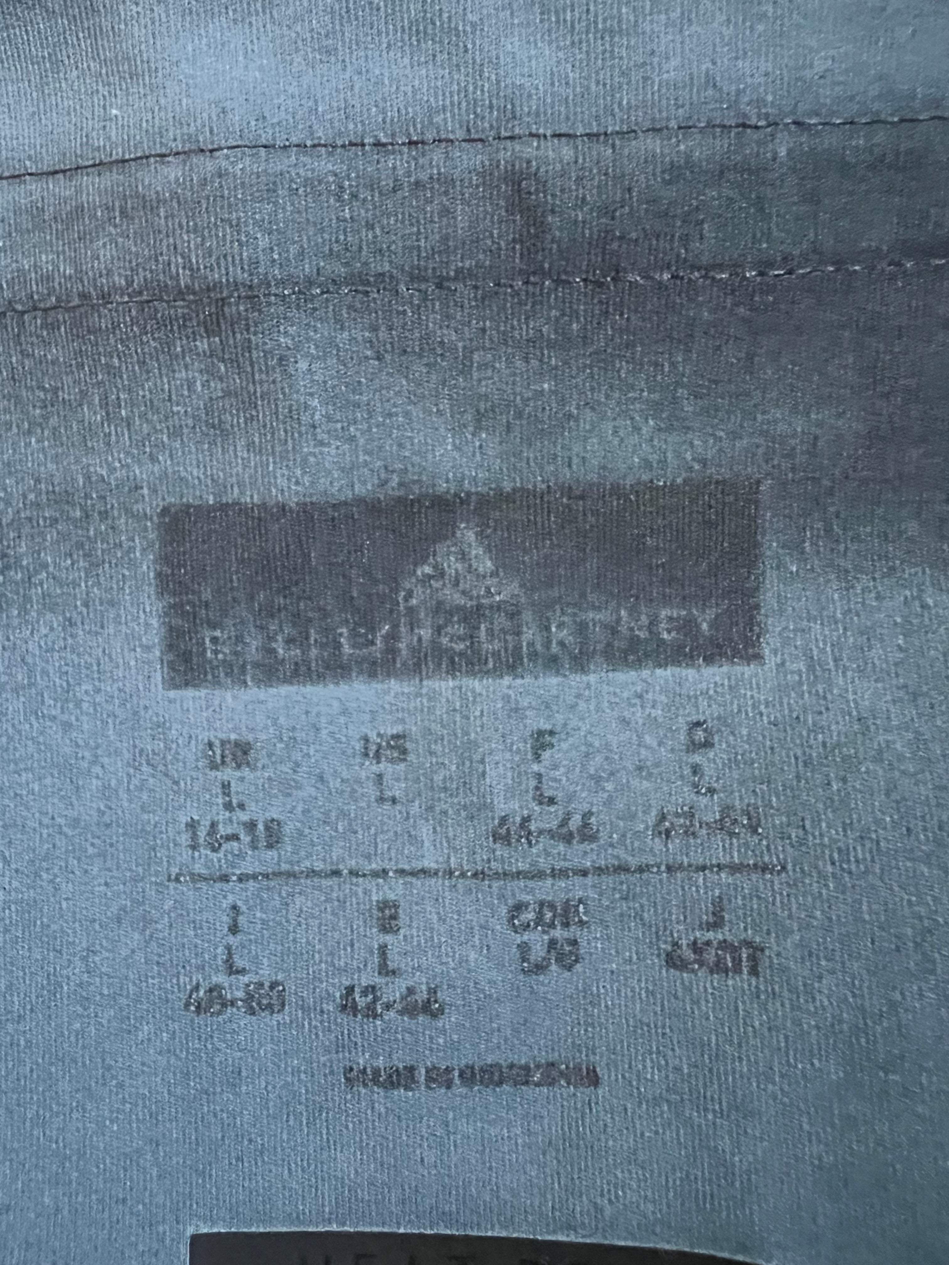 Close up of sizing and care label printed inside Adidas x Stella McCartney leggings in blue fabric
