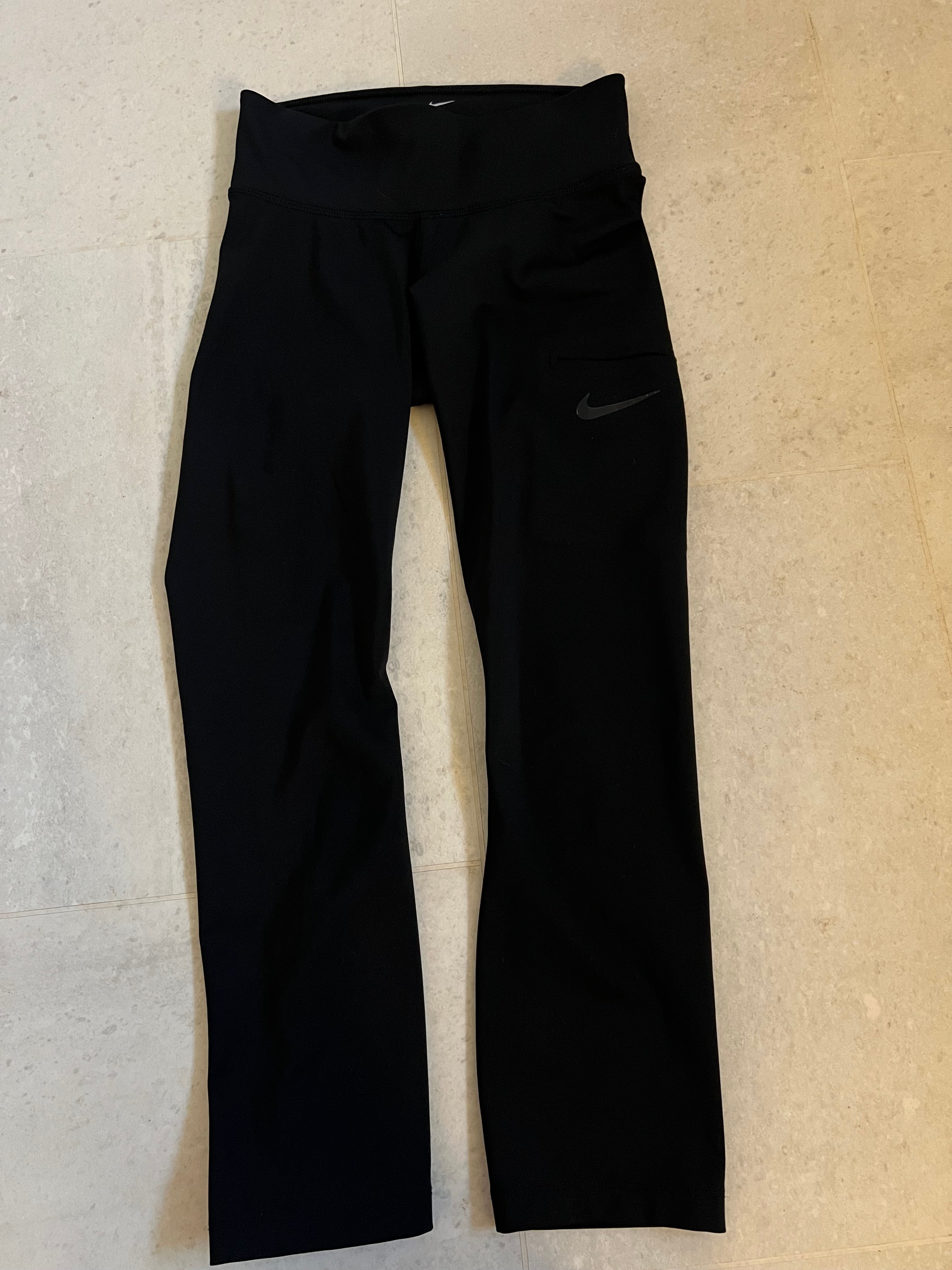 Front view of black Nike Dri-Fit cropped leggings with high waistband and side pocket