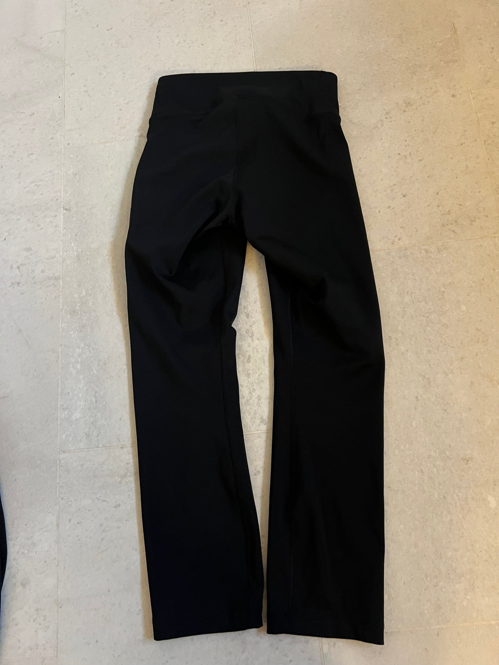 Back view of black Nike Dri-Fit cropped leggings showing smooth fabric and seam details