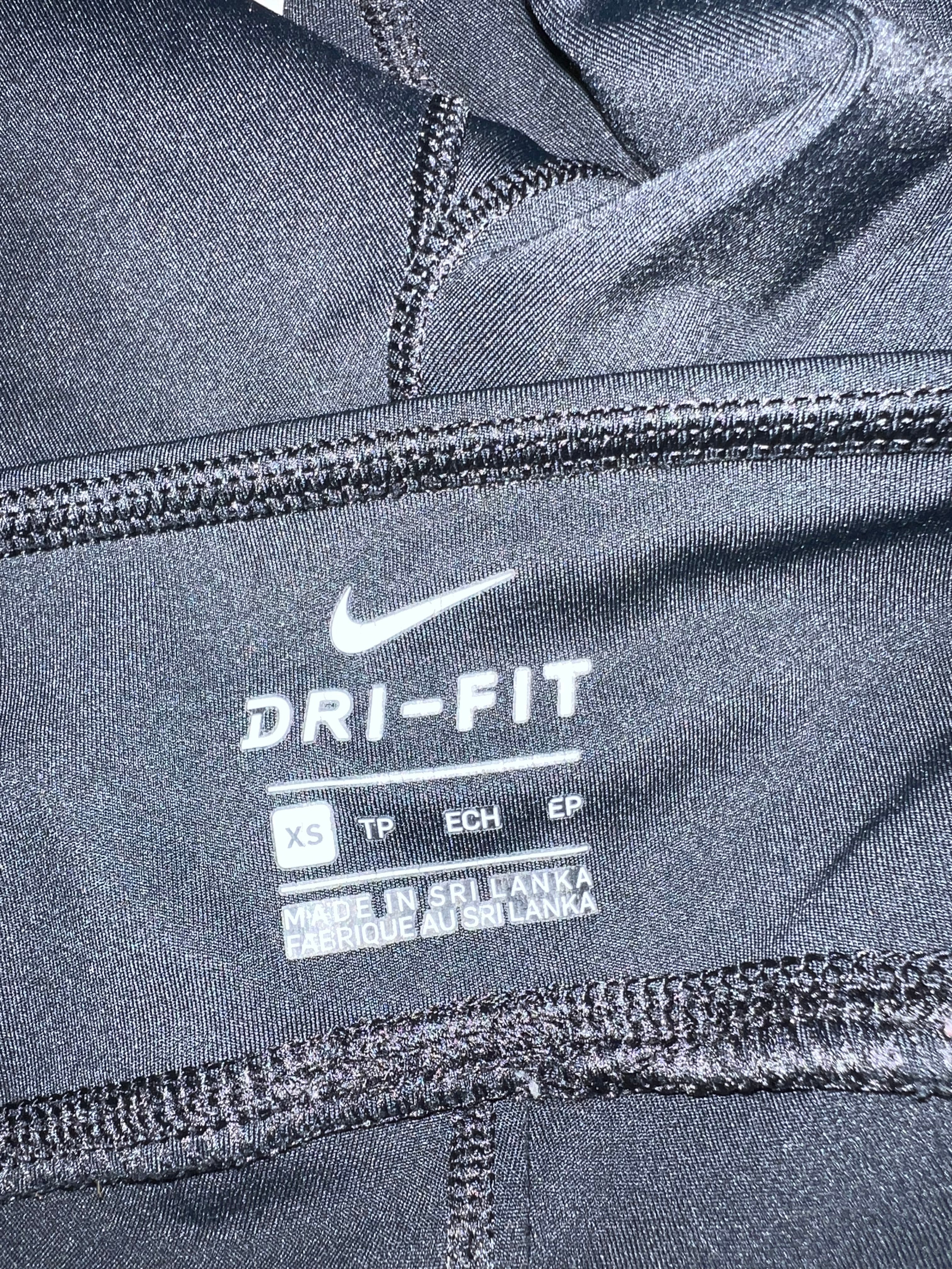 Close-up of the inner label showing Nike Dri-Fit branding and size XS in black cropped leggings
