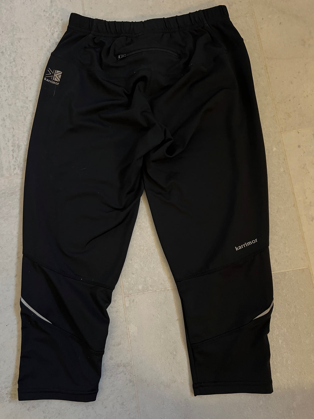 Back view of black Karrimor cropped leggings showing zipped pocket and brand logo