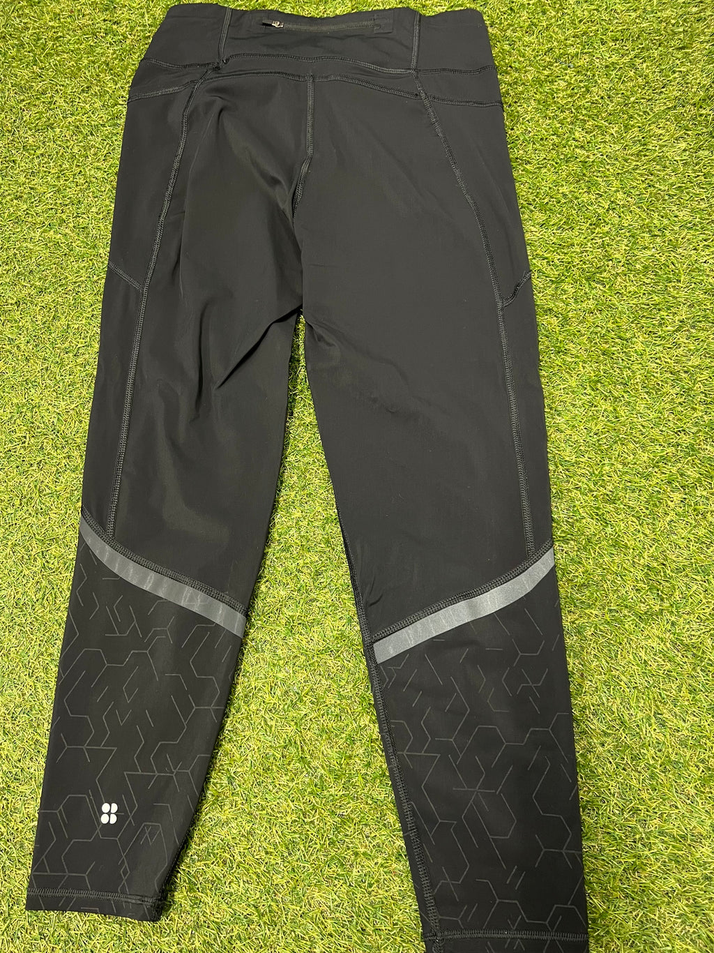 Back view of Sweaty Betty black Zero Gravity leggings showing high waistband and reflective strip