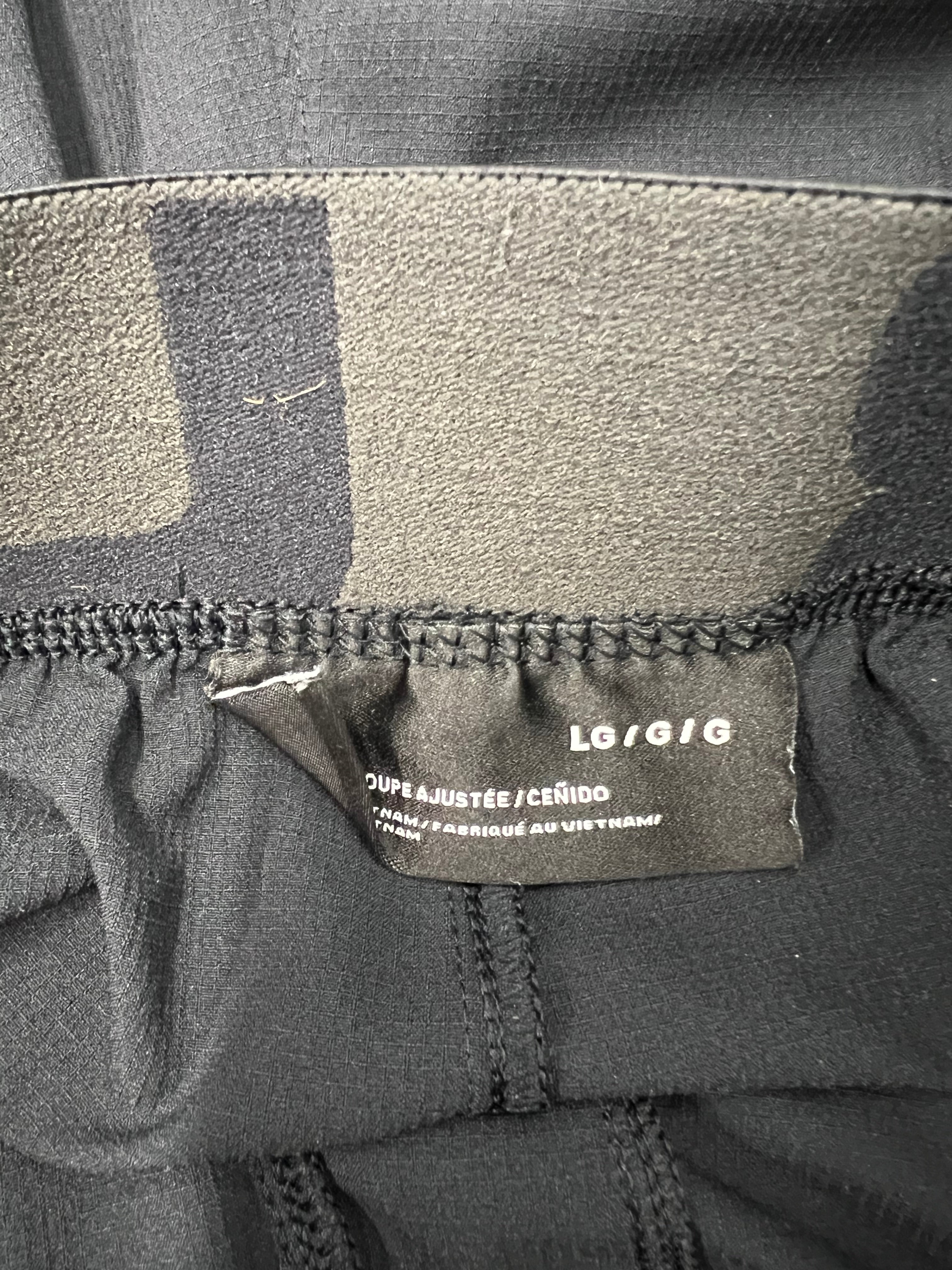 Close-up of size label inside waistband of men’s Under Armour fitted leggings, size large