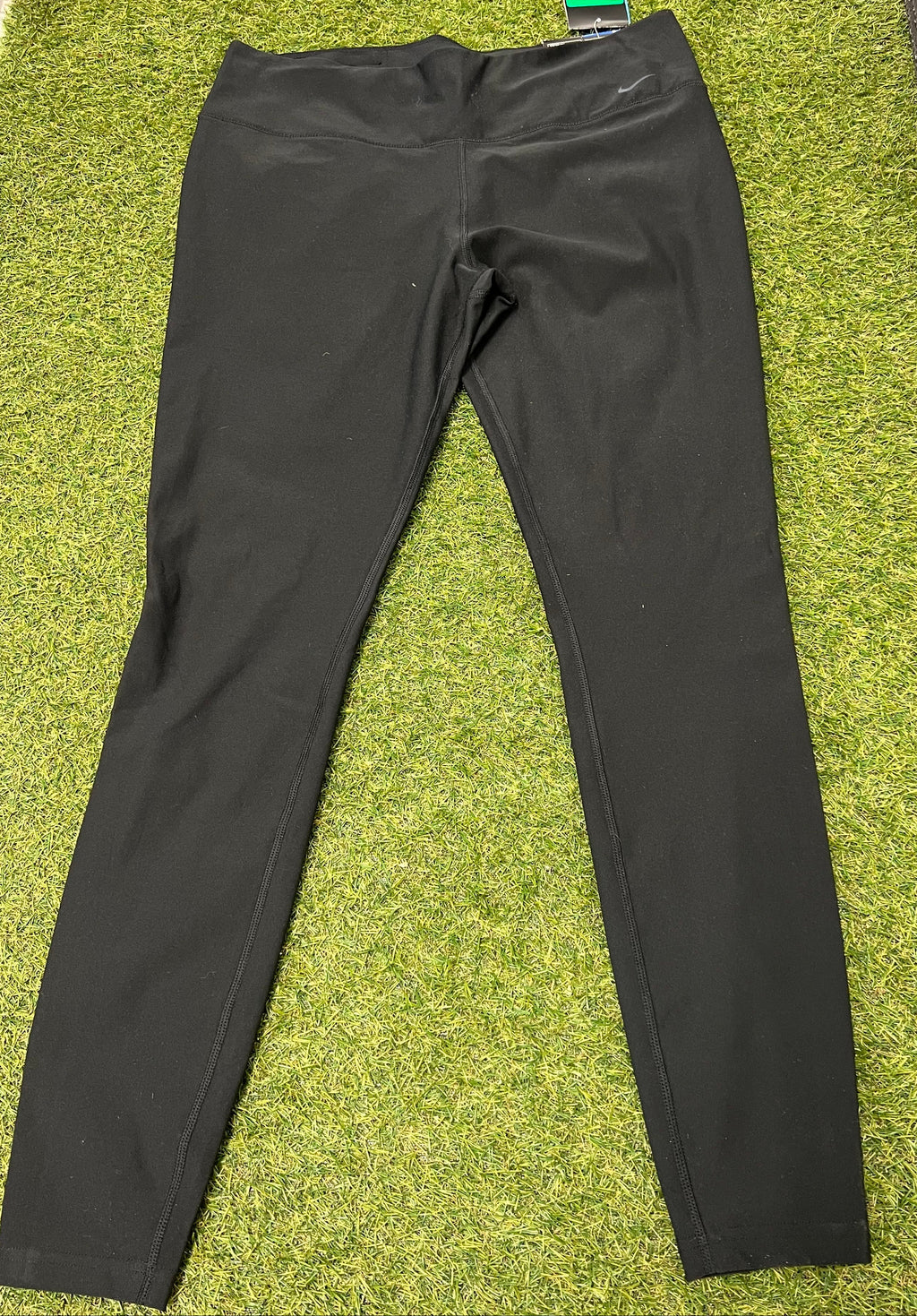 Nike black Dri-FIT leggings laid flat on green surface front view