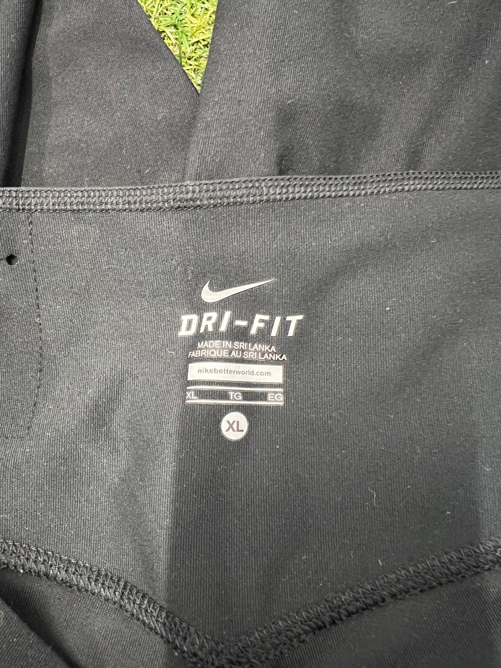 Close up of Nike Dri-FIT label inside the black leggings showing size XL and fabric details