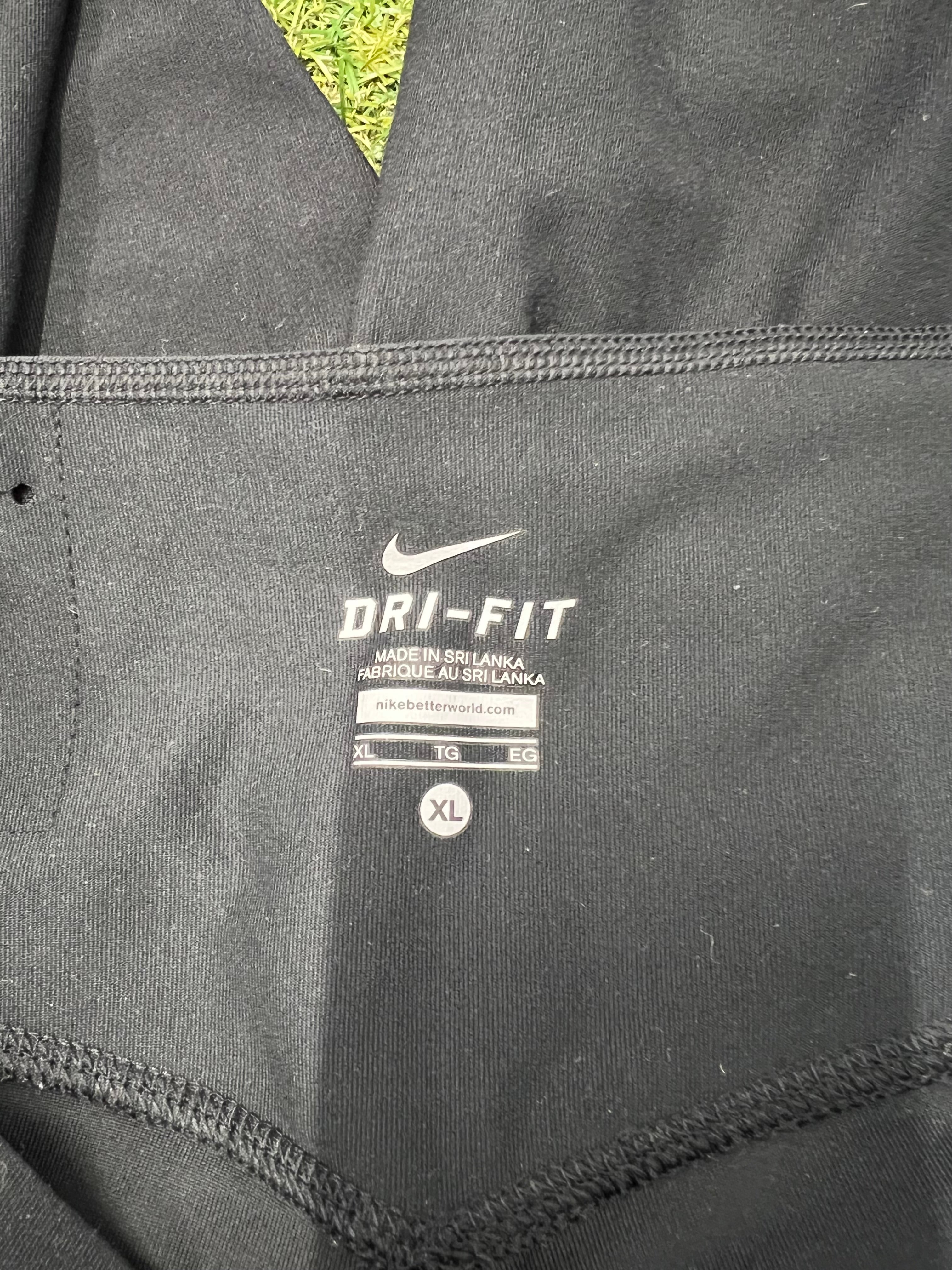 Close up of Nike Dri-FIT label inside the black leggings showing size XL and fabric details