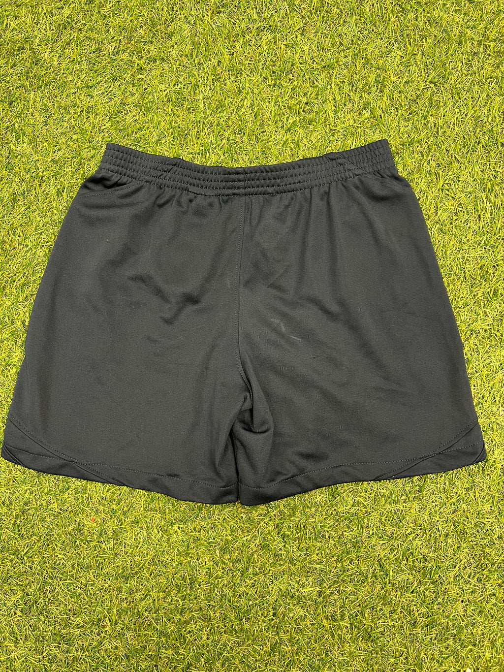 Rear view of black kids Nike Tottenham Spurs shorts on grass