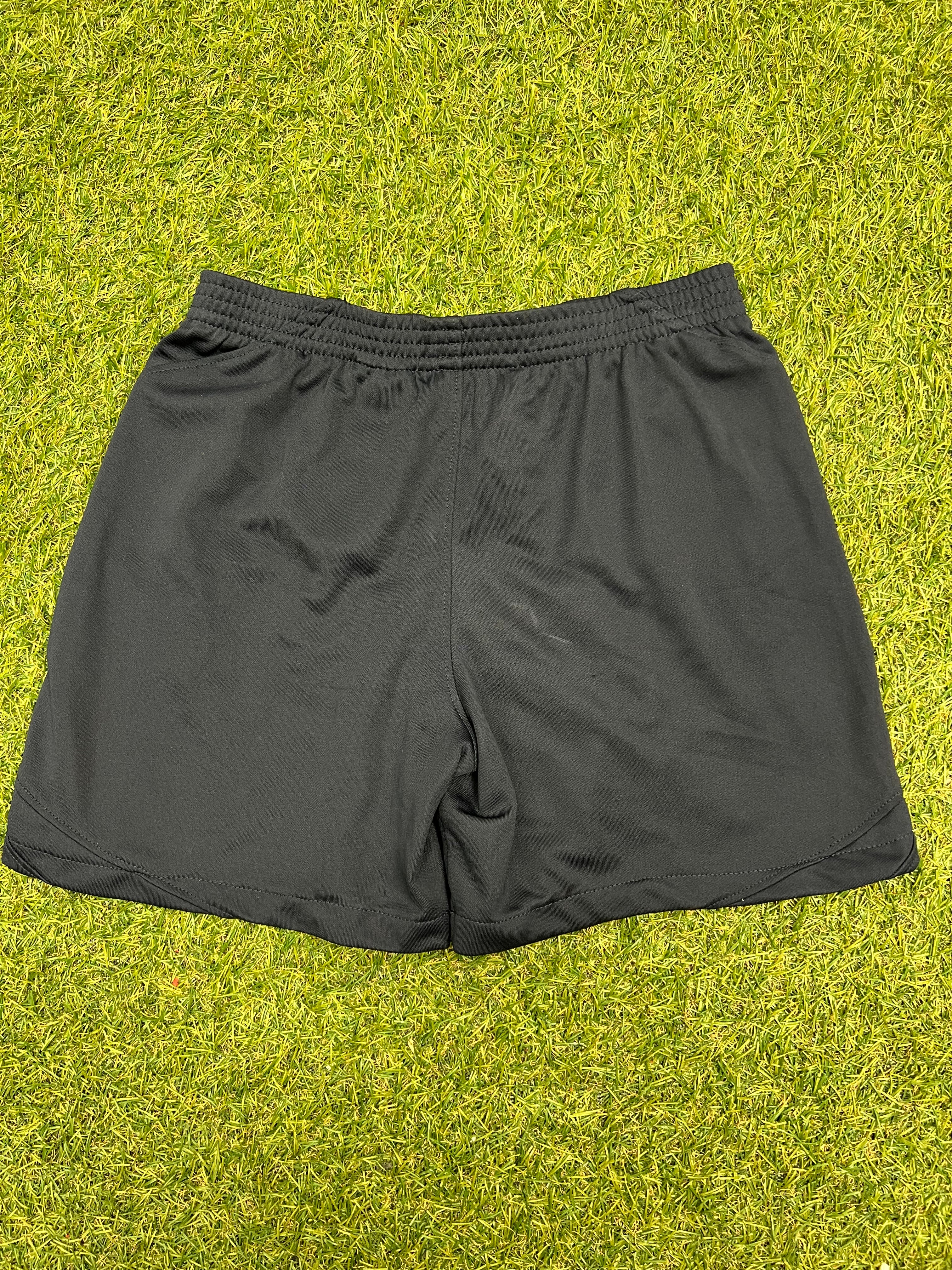 Rear view of black kids Nike Tottenham Spurs shorts on grass