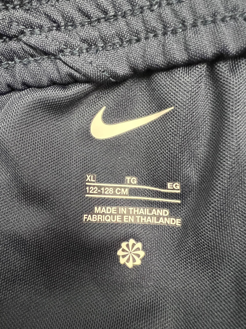 Close-up of inside label on kids Nike Tottenham Spurs shorts showing size XL, 122-128cm, made in Thailand