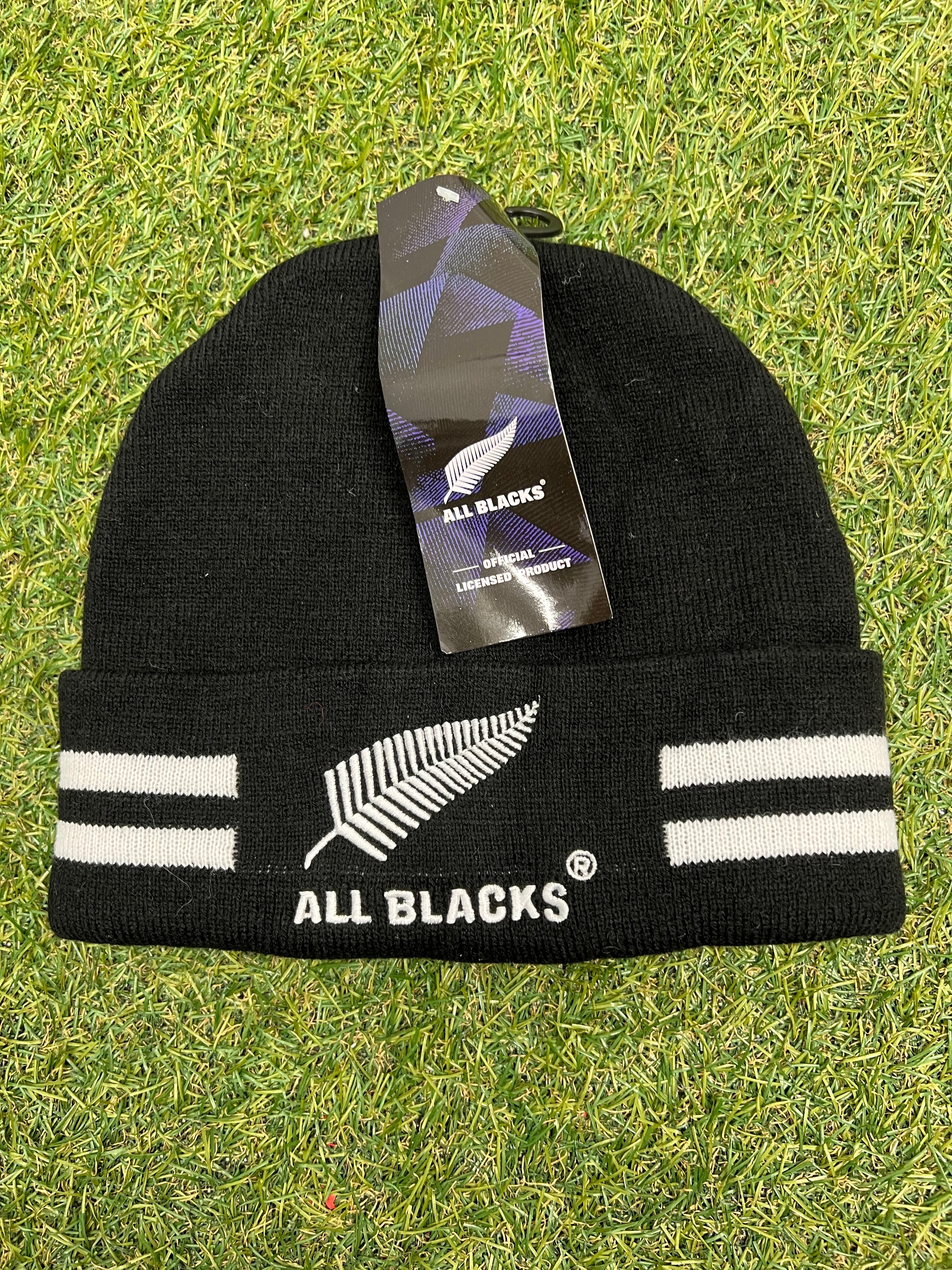 Front view of black All Blacks beanie with white embroidered silver fern and two white stripes on each side