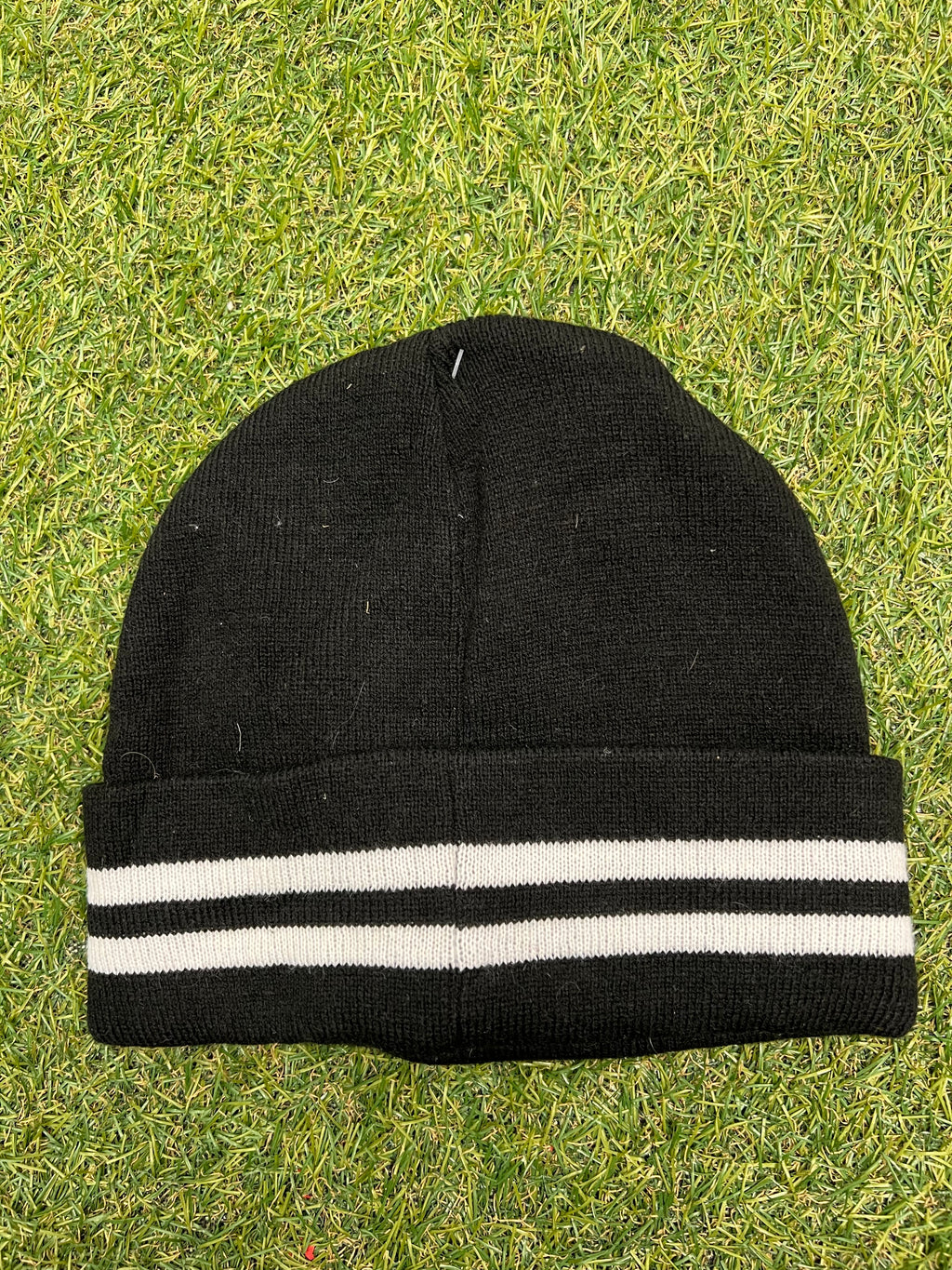 Back view of black beanie showing two white stripes on the cuff