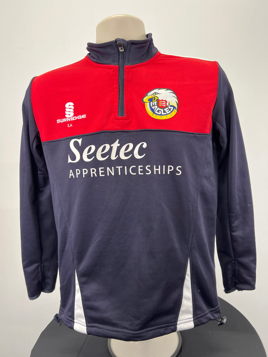 Front view of Essex Eagles half-zip top in red and navy with Seetec Apprenticeships branding
