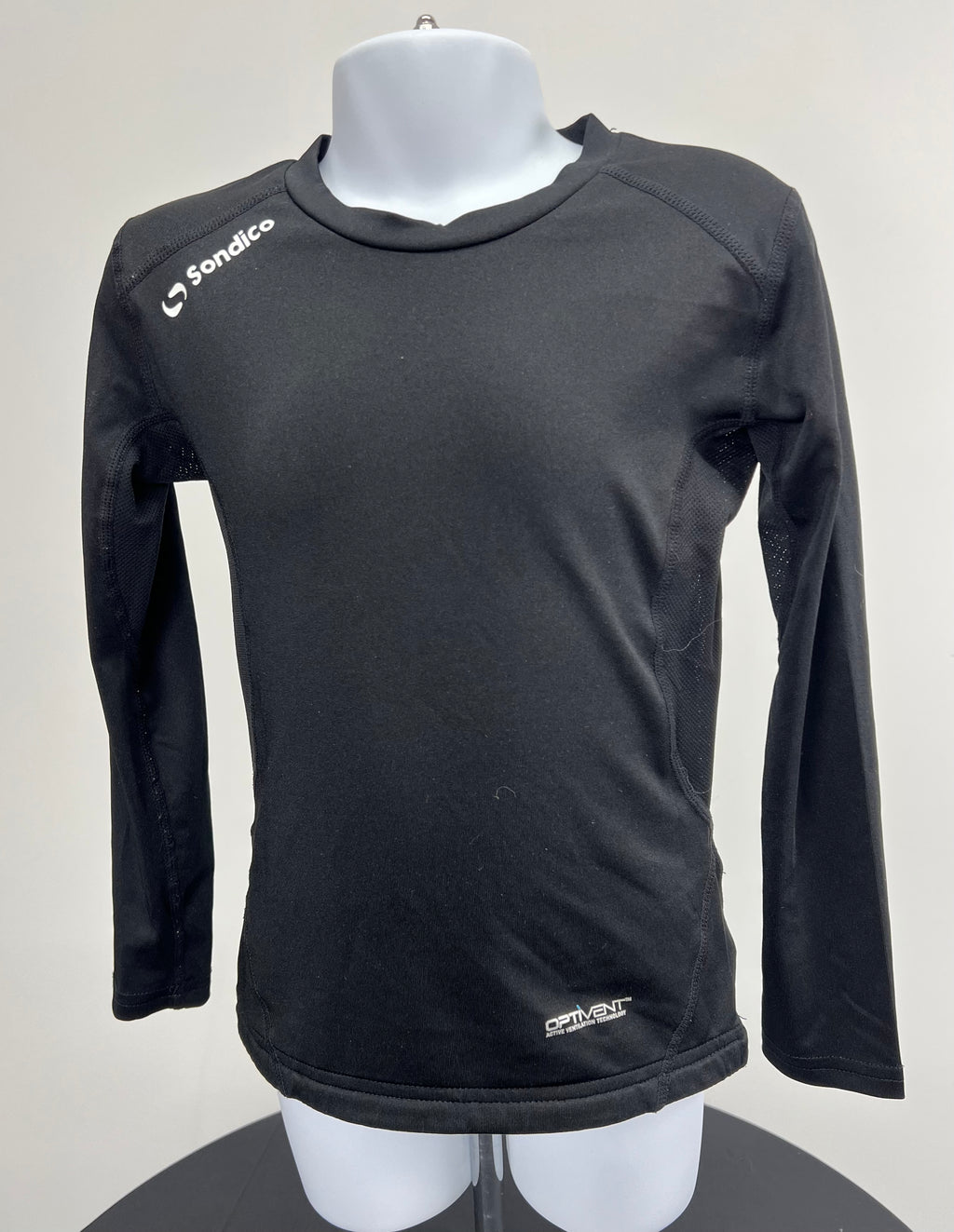 Front view of black kids long sleeve Sondico base layer top with white logo on shoulder