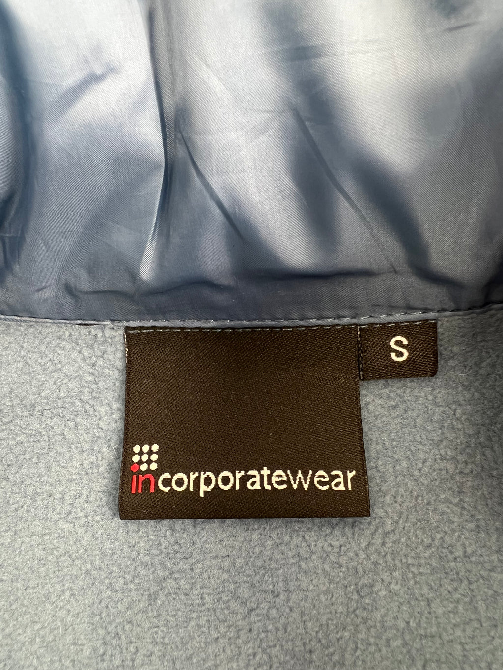 Close-up of fleece lining and size S label from incorporatewear inside the gilet