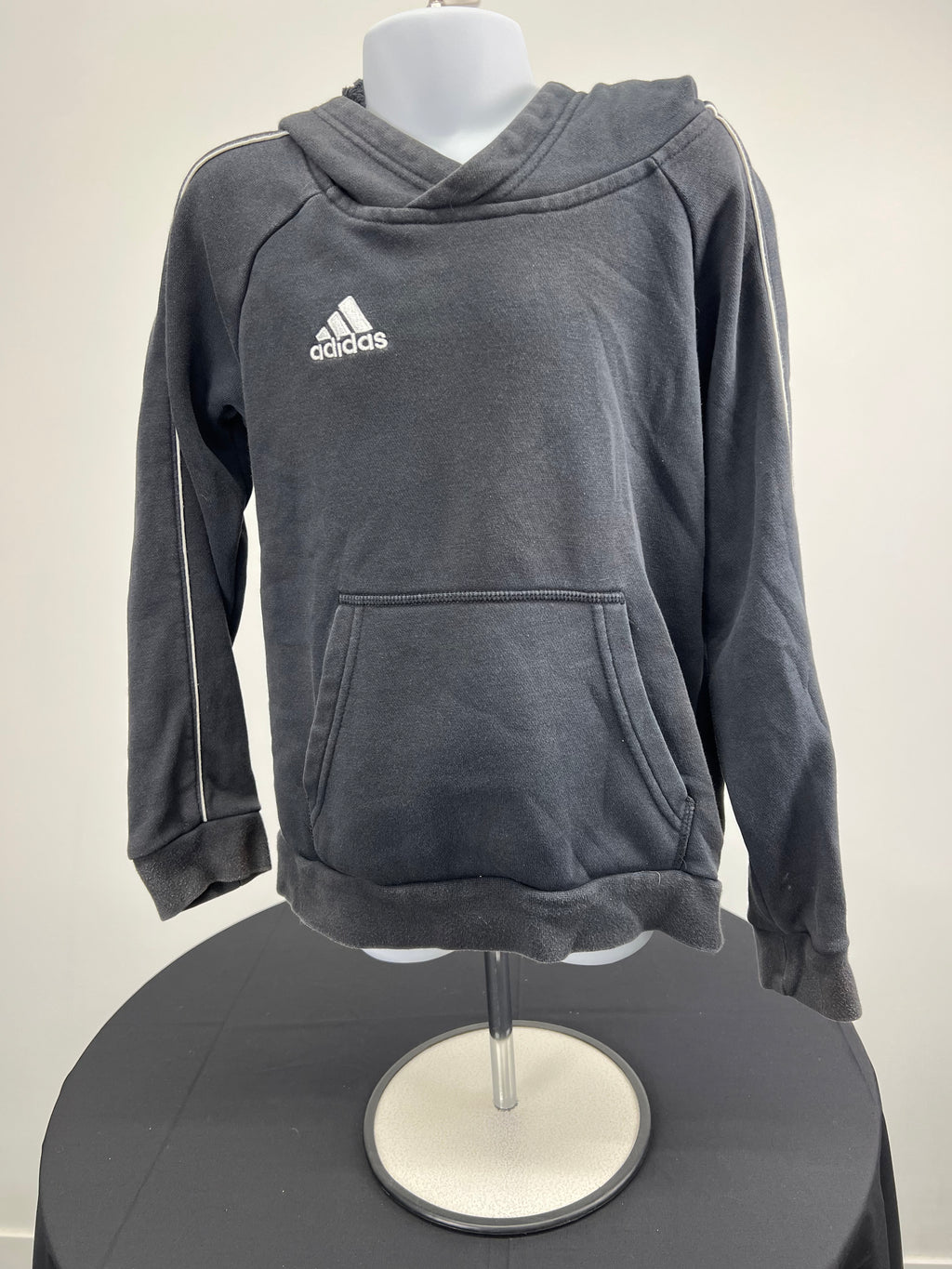 Front view of kids' black adidas hoodie with white logo and stripe details on sleeves