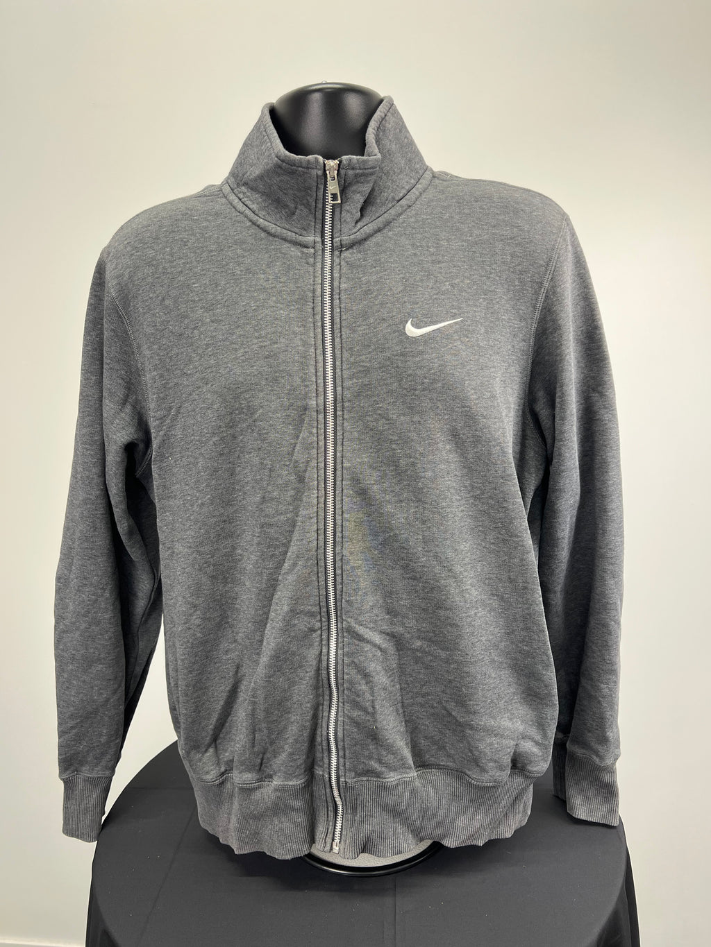 Front view of Nike medium grey zip-up top with white swoosh logo and silver zipper
