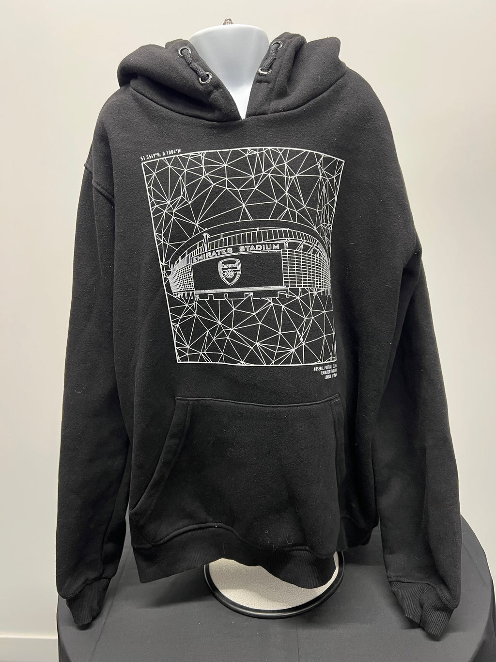 Front view of black kids Arsenal hoodie with white geometric Emirates Stadium print