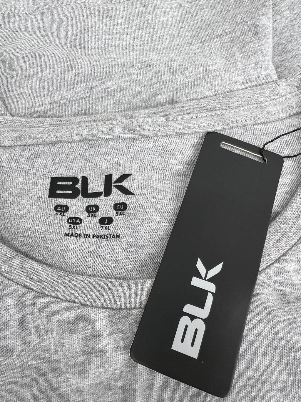 Close-up of BLK brand label and tag on grey Exiles print t-shirt