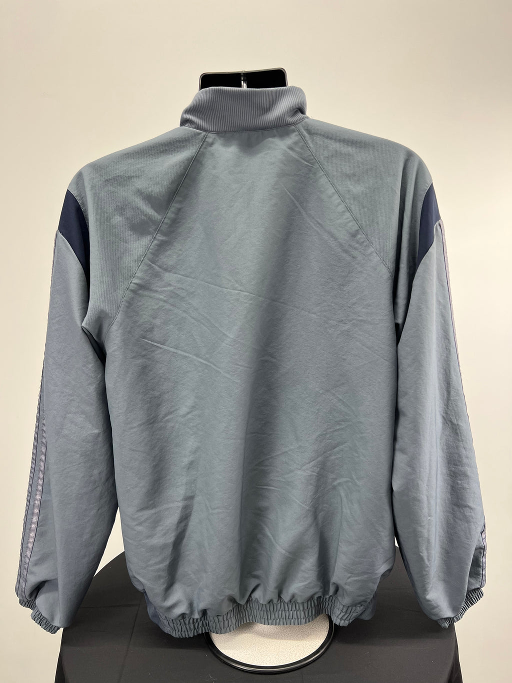 Back view of grey Adidas half zip top showing plain design and elasticated hem