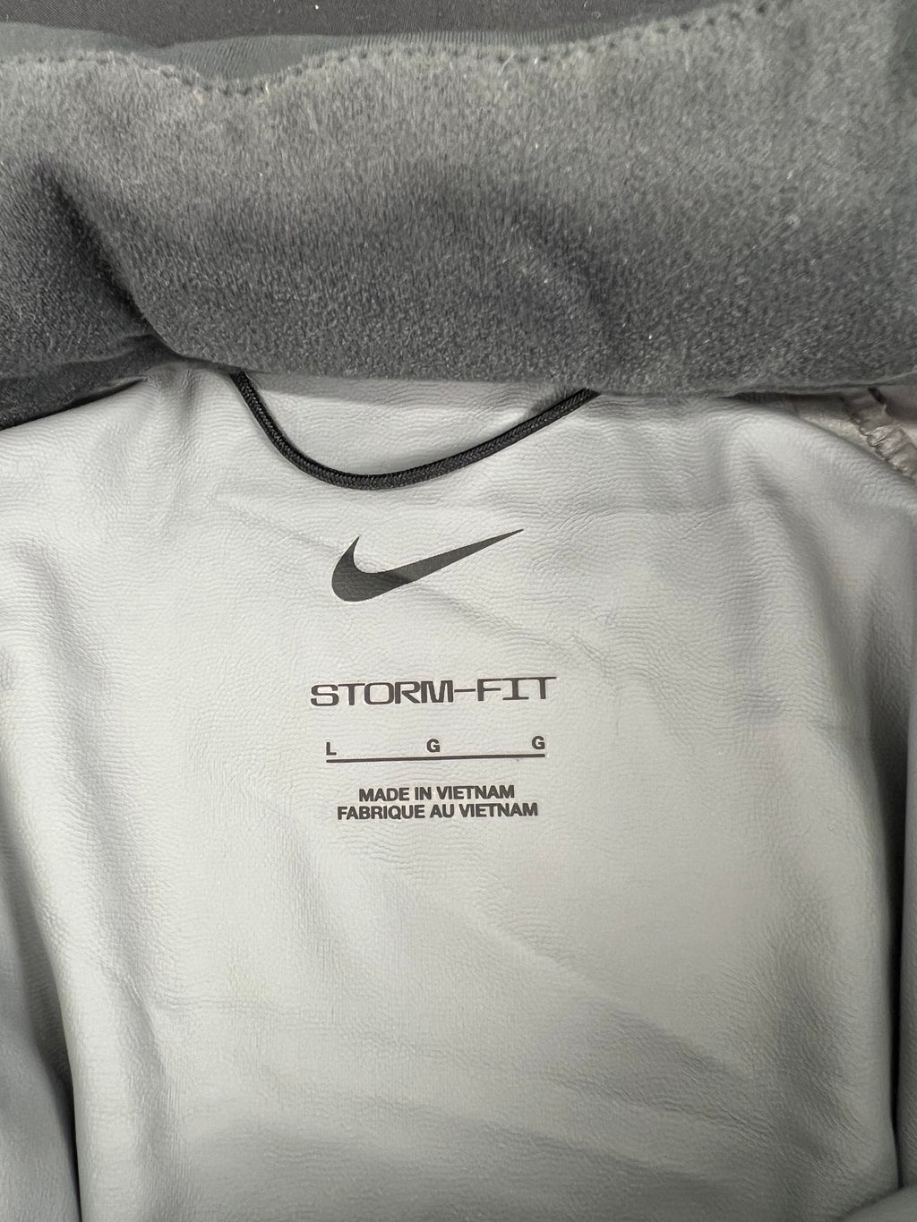 Inside label of Nike Storm-Fit jacket showing size Large and made in Vietnam