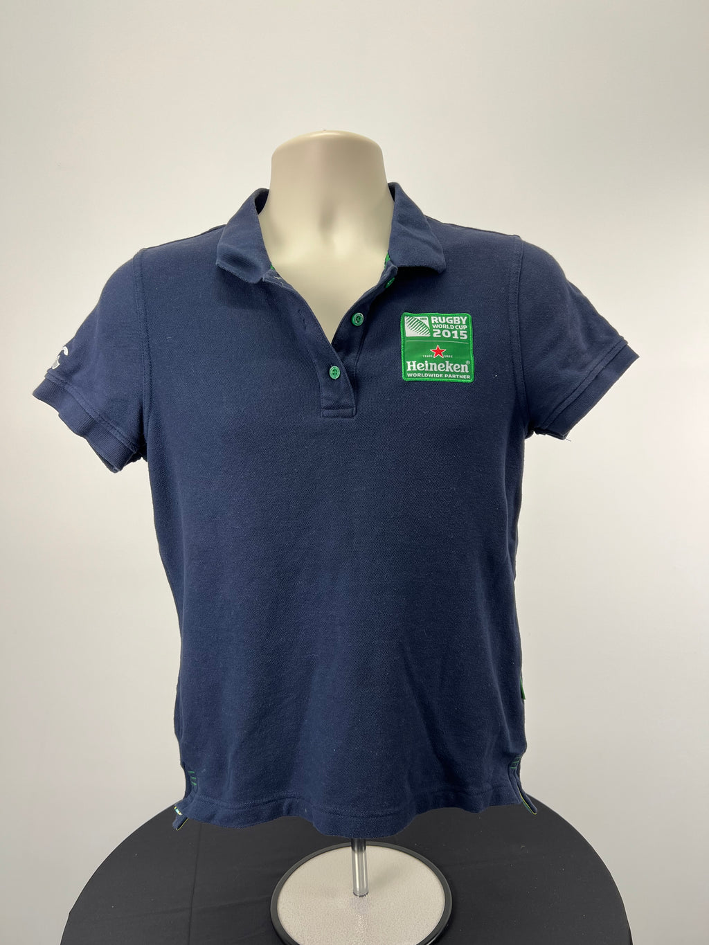 Front view of women's dark blue Rugby World Cup 2015 polo shirt with Heineken patch