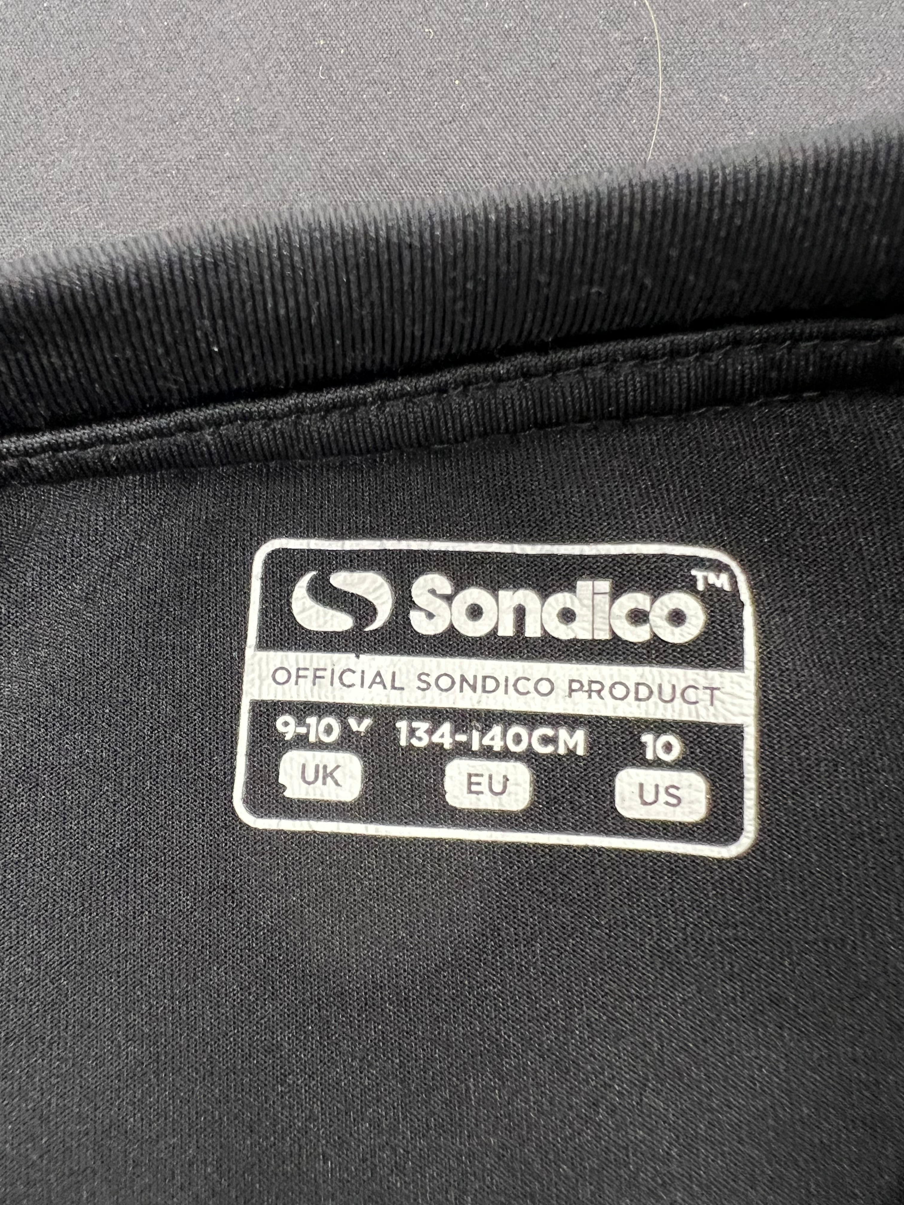 Close-up of Sondico brand label inside the black kids base layer, size 9-10