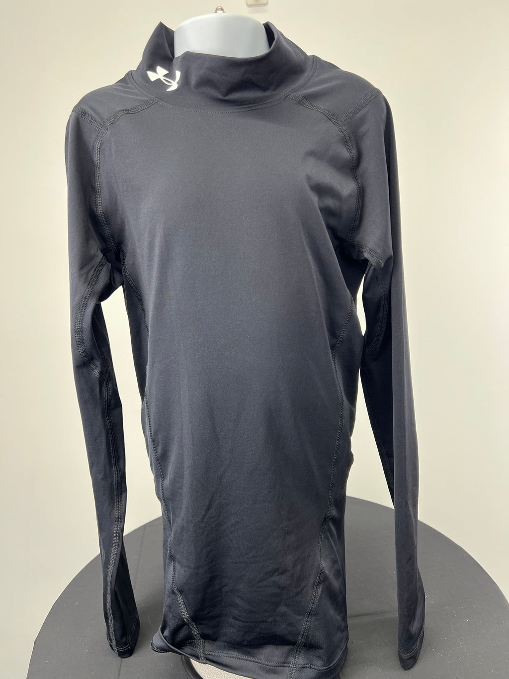 Front view of black Under Armour compression long-sleeve top with high collar and logo on neck