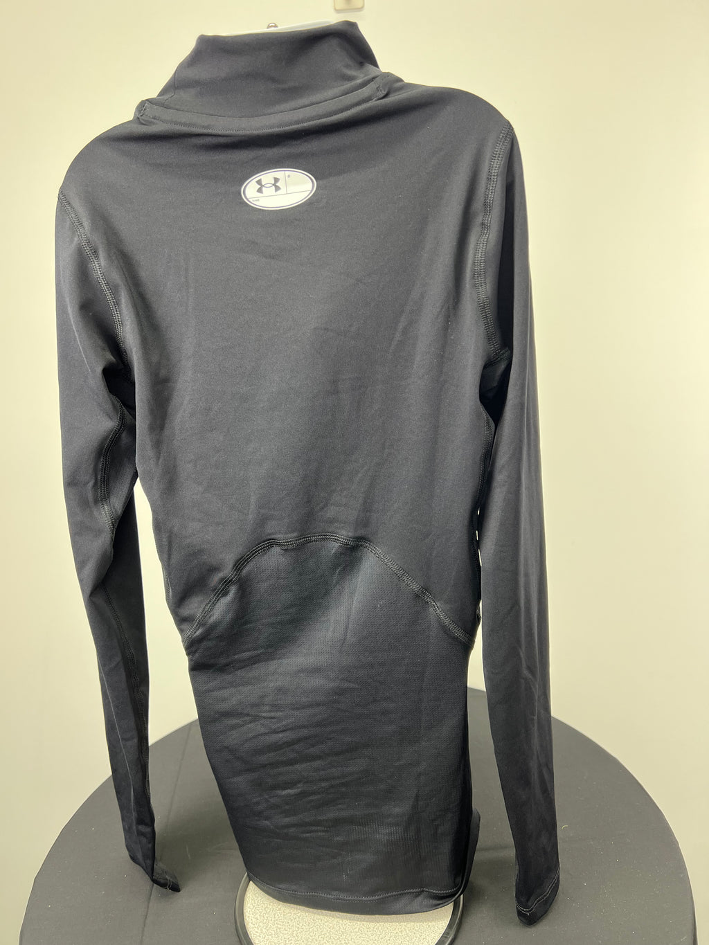 Back view of black Under Armour compression top showing high collar and fabric texture