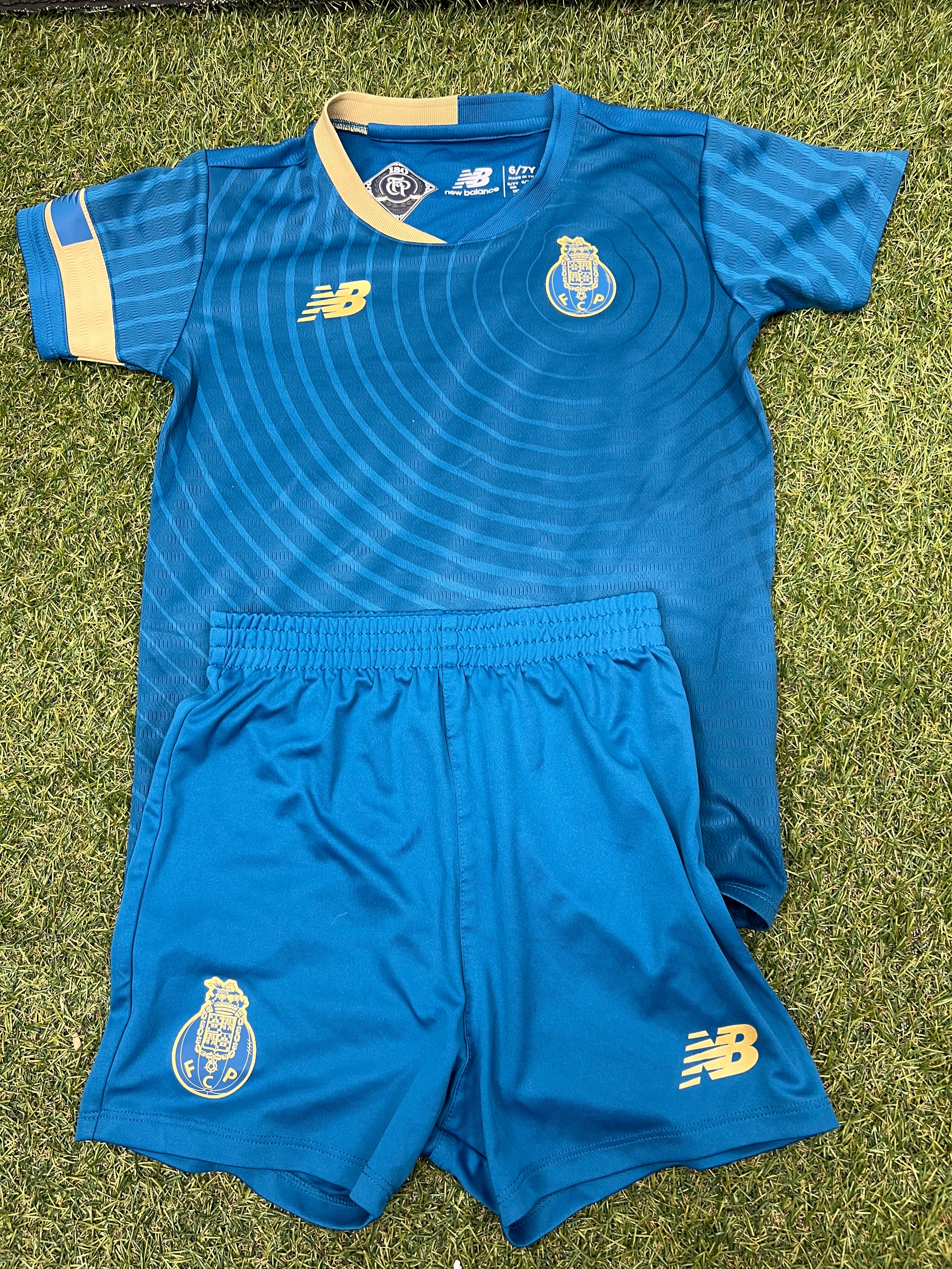 Front view of kids FC Porto football strip featuring blue shirt with circular pattern and yellow trims alongside matching blue shorts
