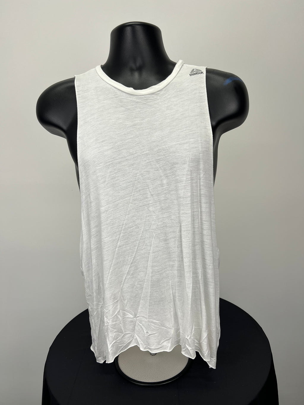 Front view of white Reebok sleeveless Body Combat vest on black mannequin