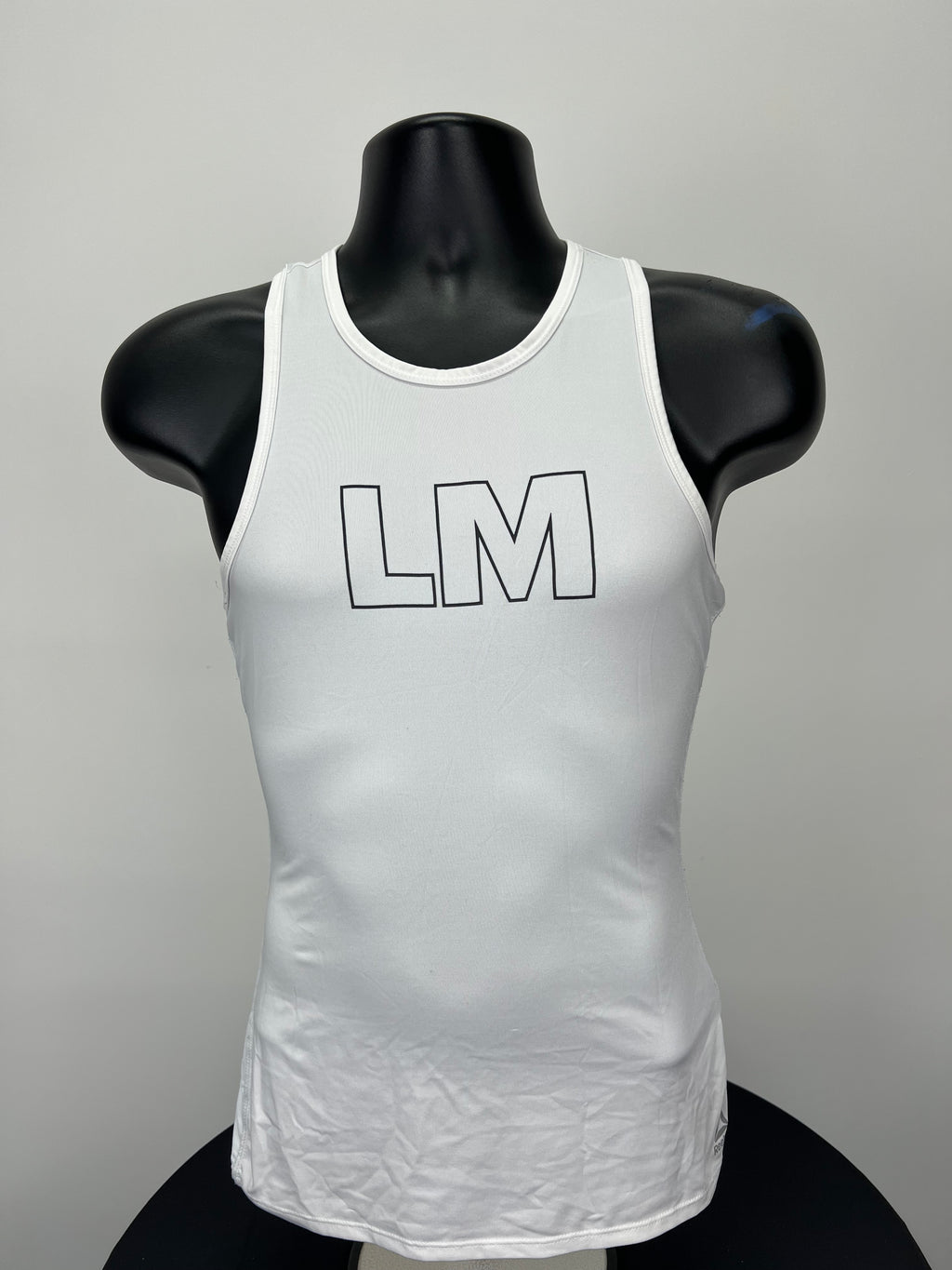 Front view of white Women’s Reebok Les Mills sports vest with LM logo