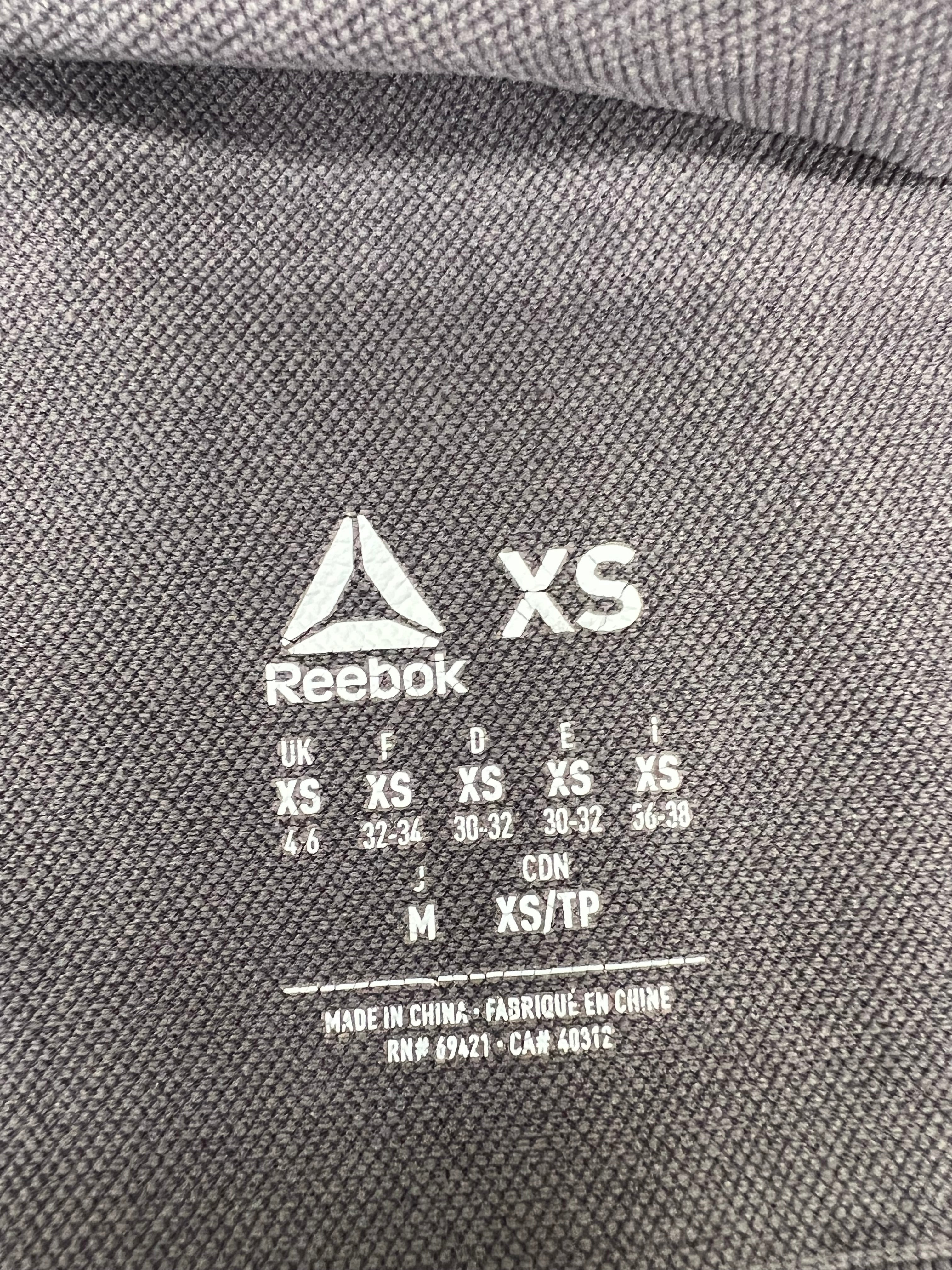 Close-up of sizing and care label on Reebok x Les Mills grey vest top size XS