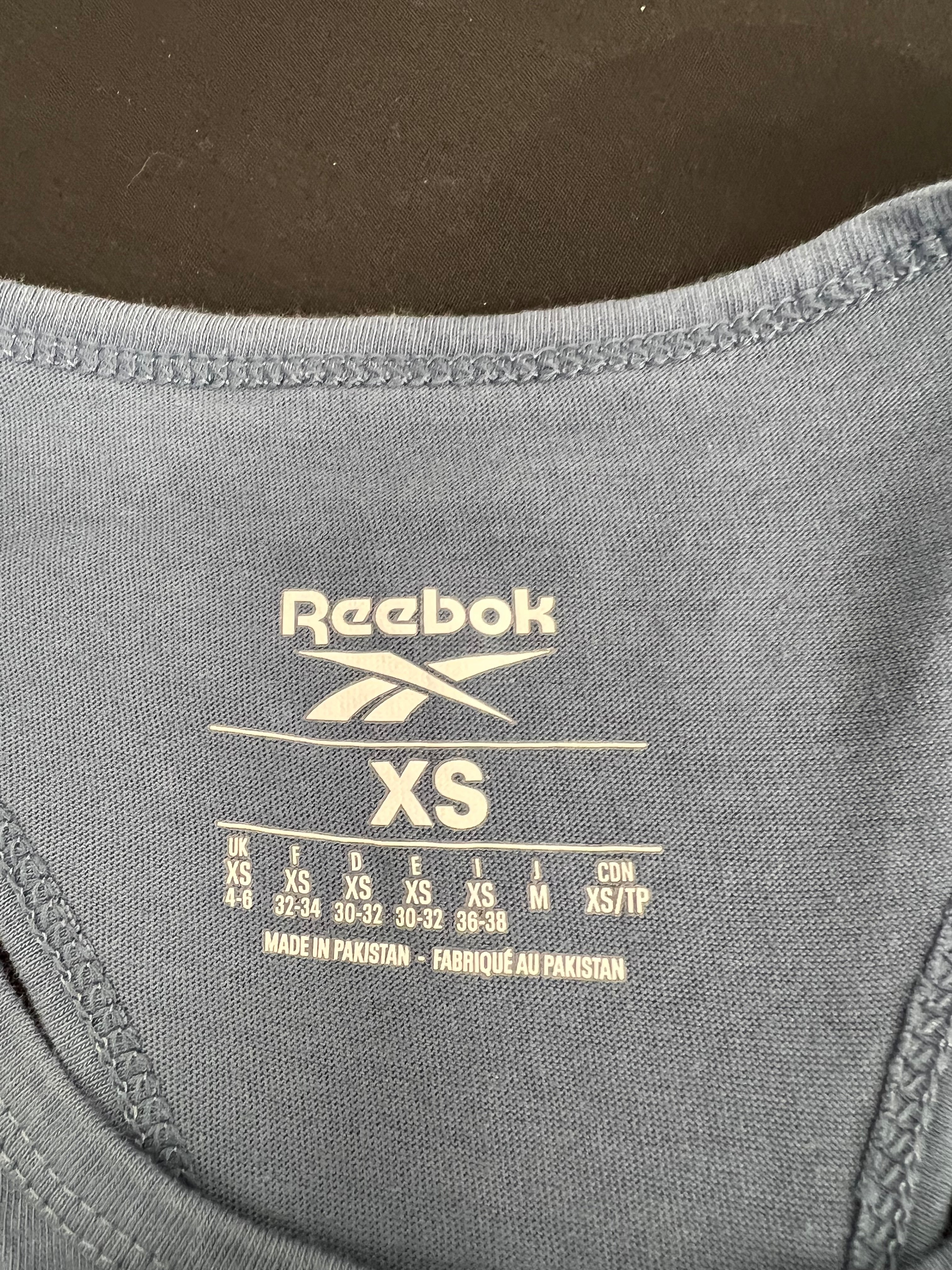 Size label inside Reebok x Les Mills grey vest top showing XS and made in Pakistan