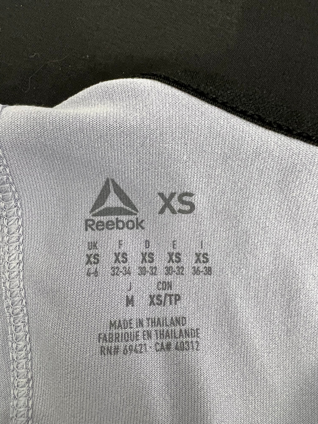 Close-up of Reebok vest top size label indicating XS size and made in Thailand