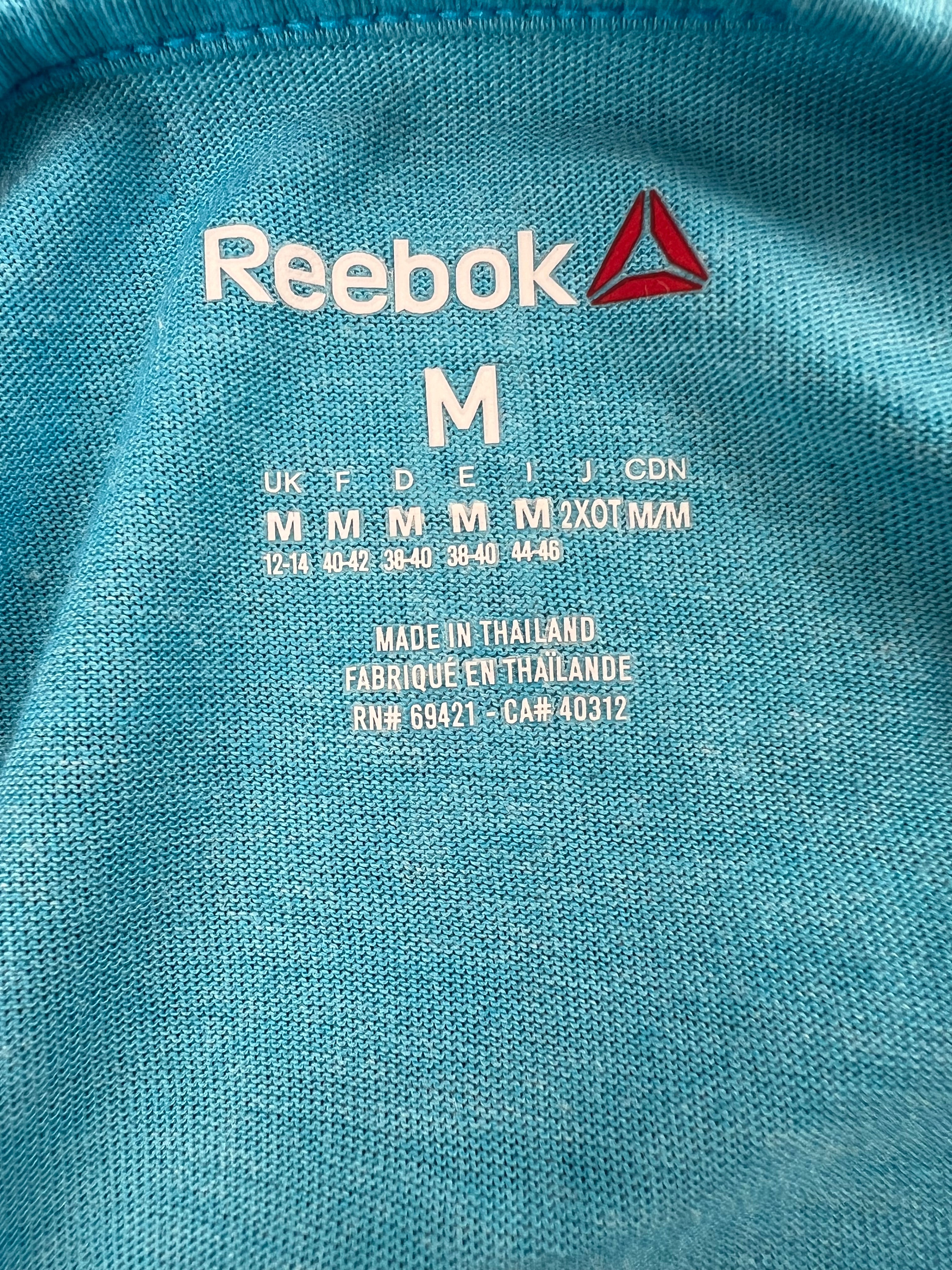 Close-up of size label and Reebok logo printed inside turquoise training vest