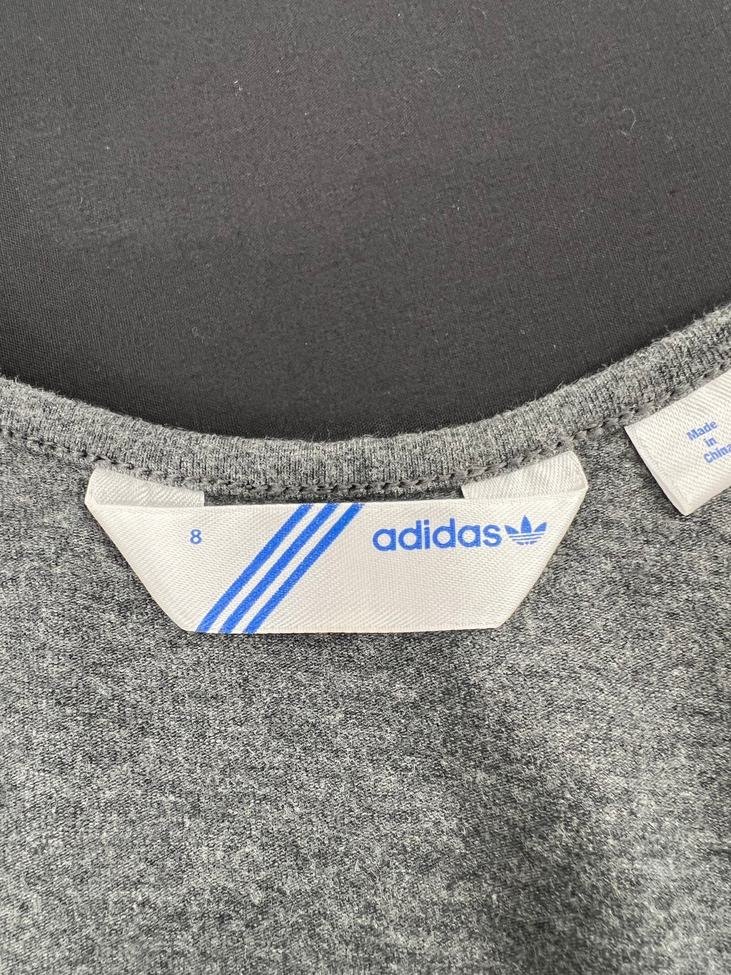 Close-up of adidas size 8 label inside grey training vest