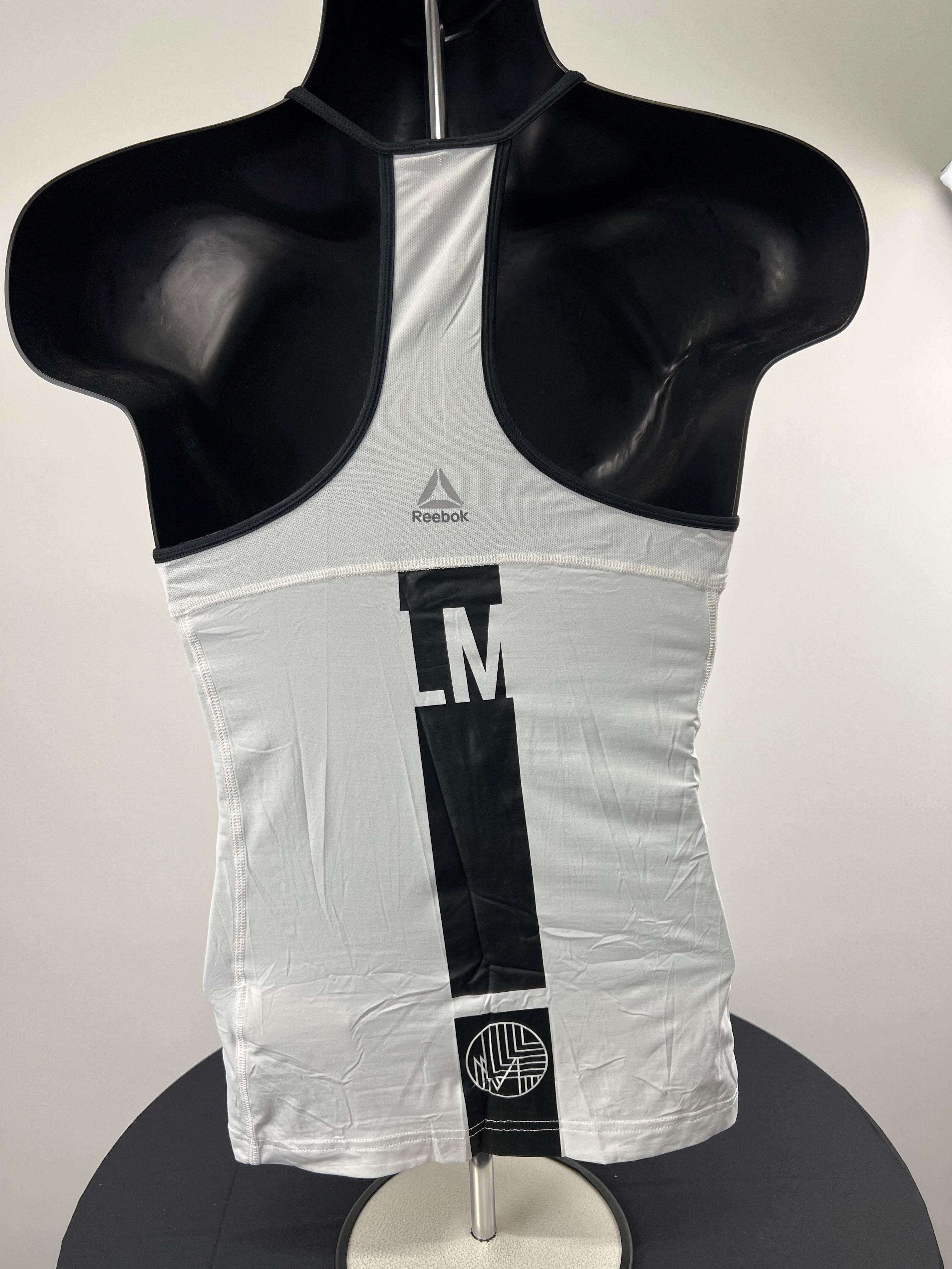 Rear view of white Reebok x Les Mills training vest showing black vertical stripe and logos on mannequin