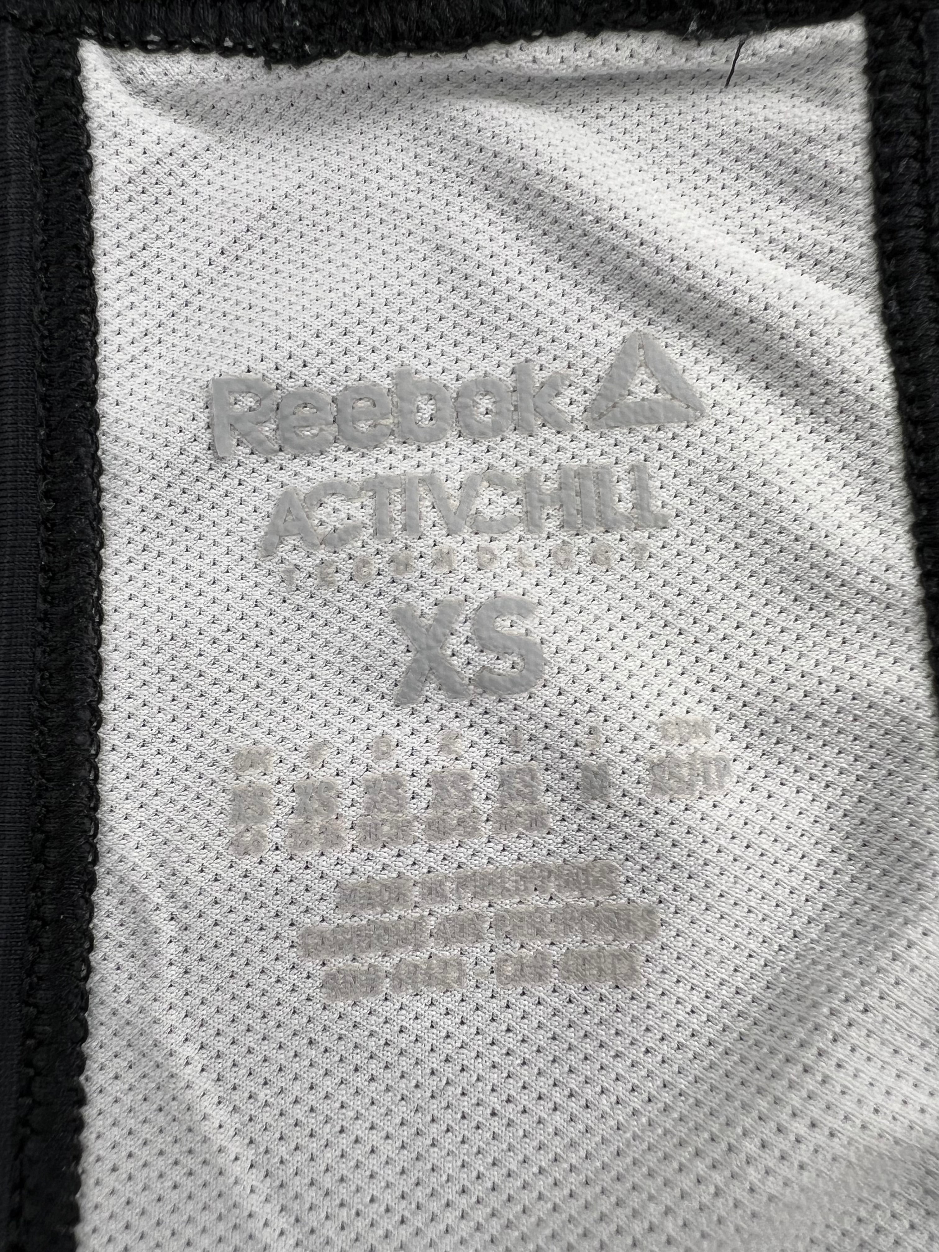 Close-up of Reebok Activchill size XS label inside white training vest