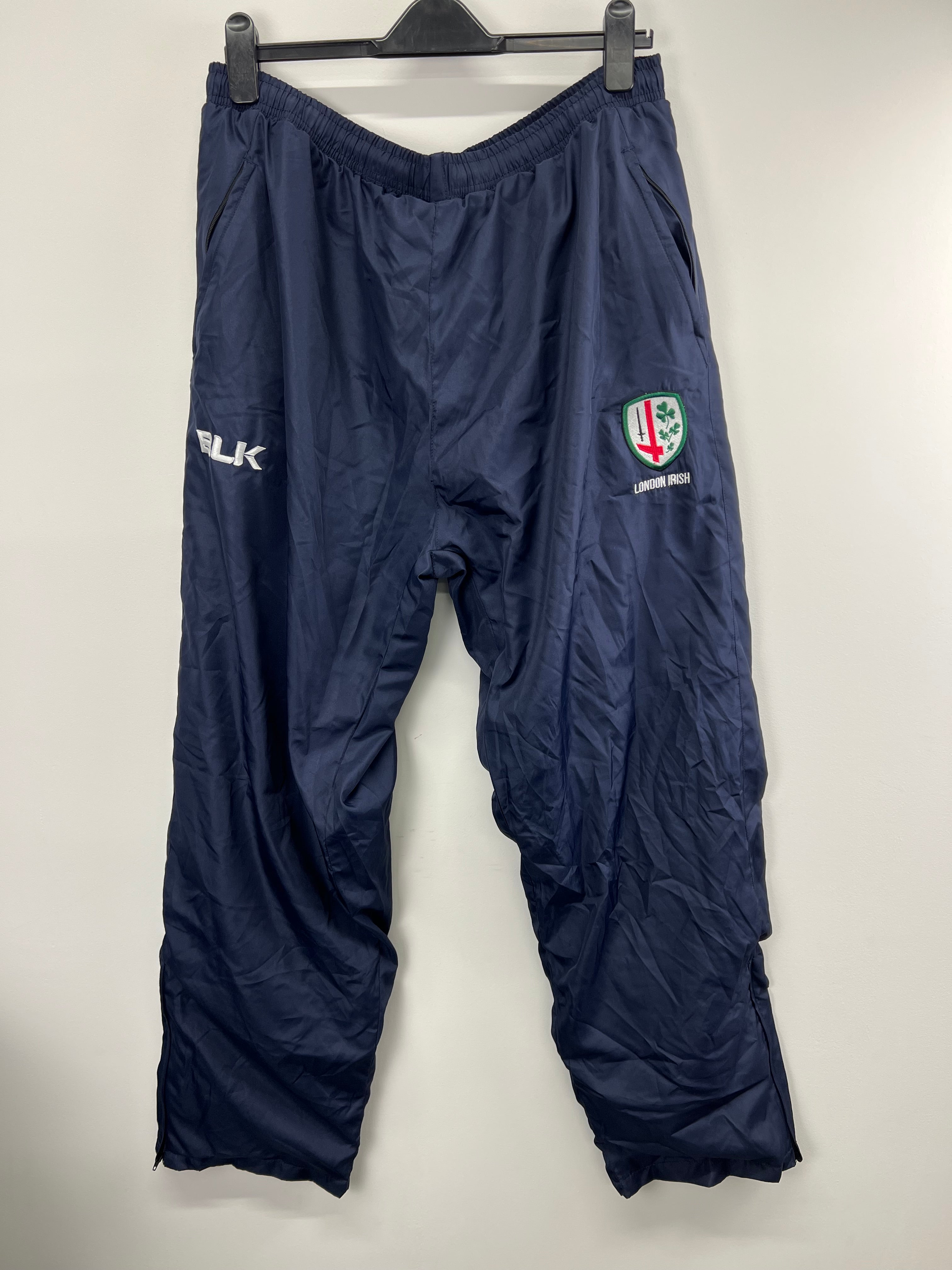 Men's navy blue BLK London Irish tracksuit bottoms front view with London Irish crest and BLK logo
