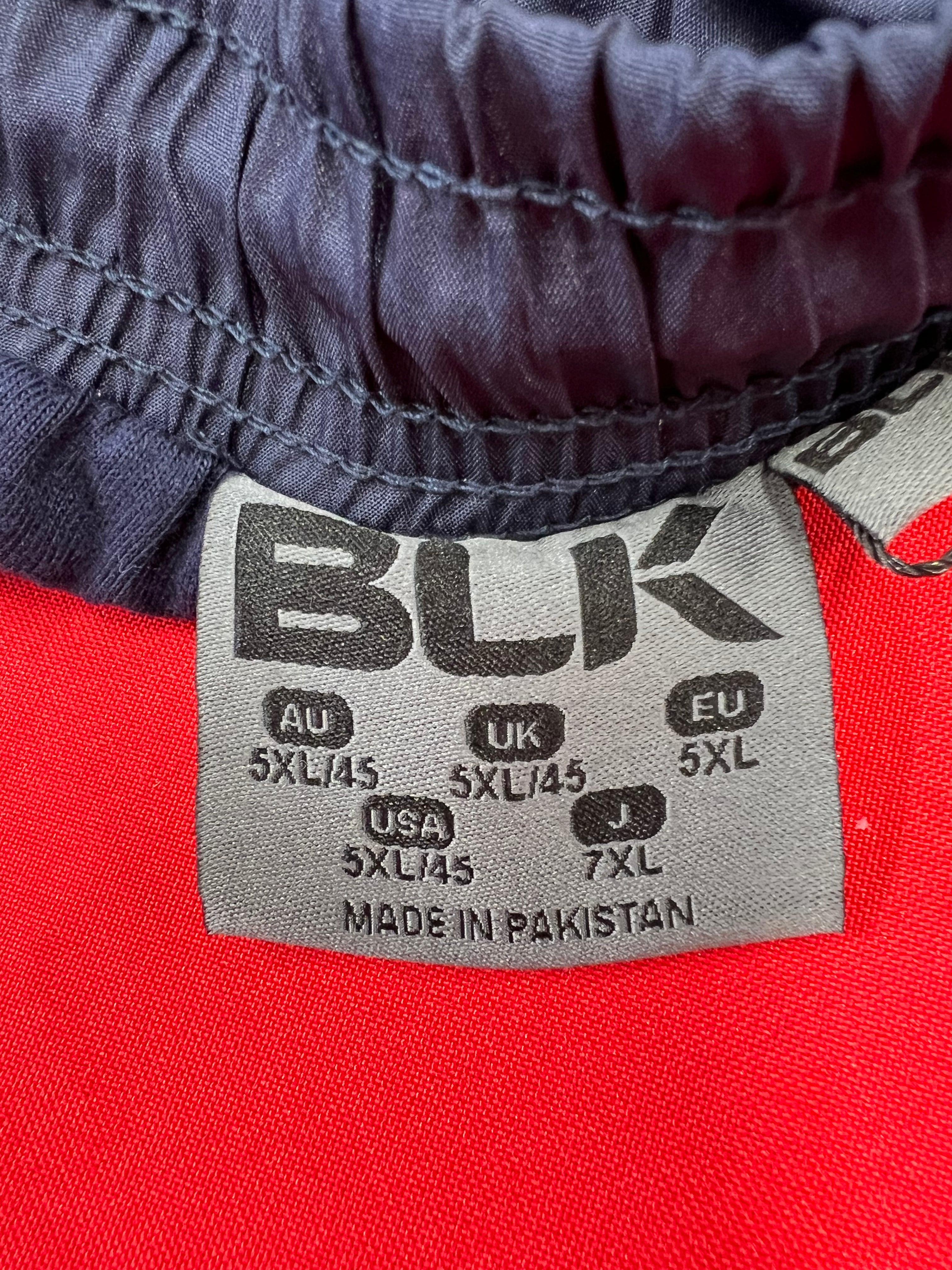 Size label inside navy blue tracksuit bottoms showing 5XL and manufacturing details