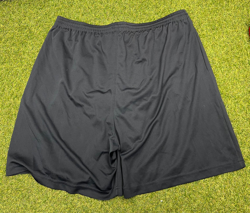 Back view of plain black England Rugby shorts on a grass background