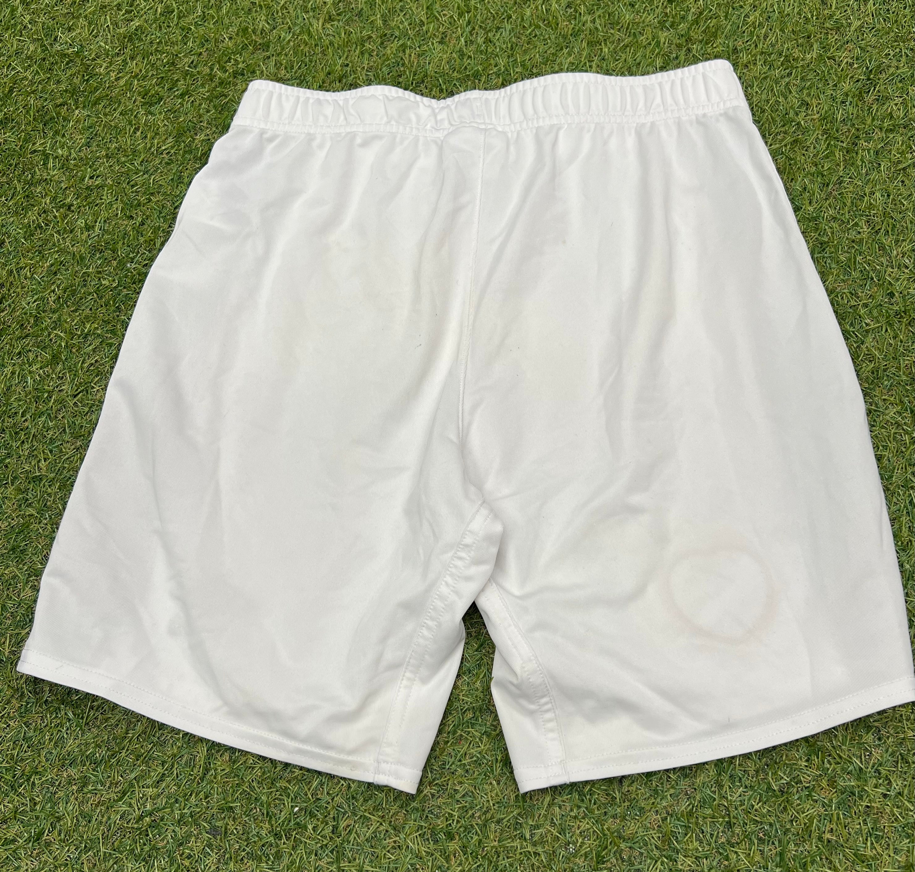 Back view of Men’s Umbro Hearts FC football shorts in white with elastic waistband on grass