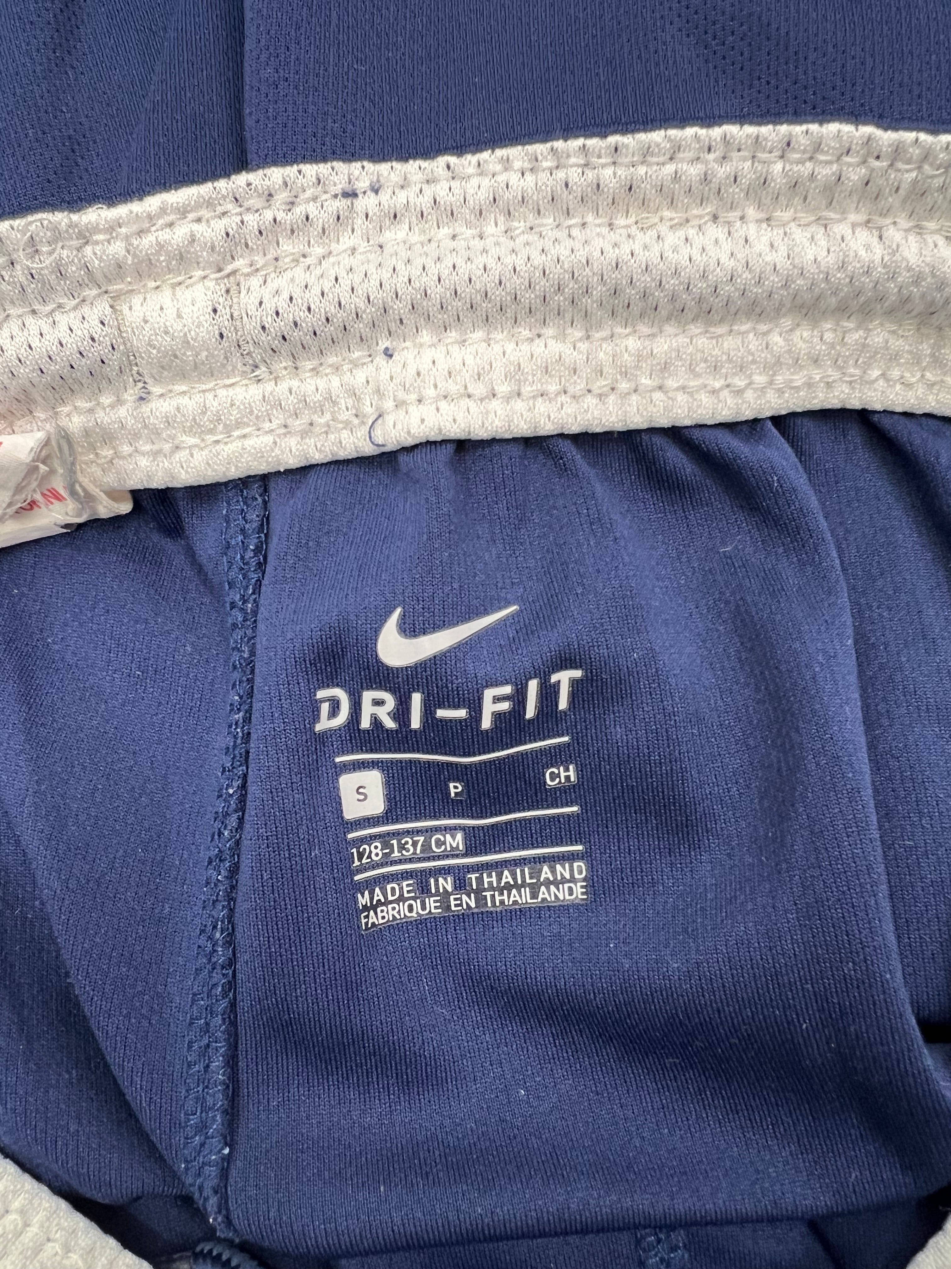 Close-up of inside label showing Nike Dri-FIT logo and size on kids Tottenham Hotspur shorts