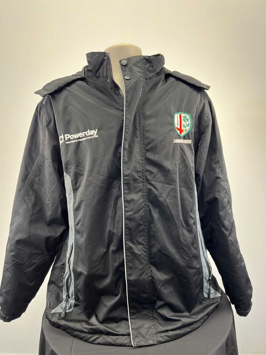 Front view of men’s London Irish black hooded jacket with logos and zip pockets